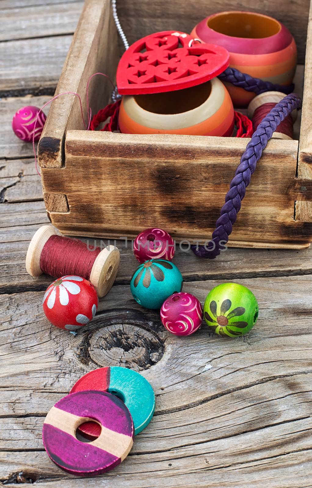 accessories of beads and threads for needlework on wooden plank