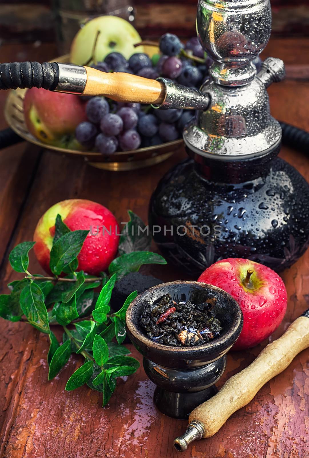 Hookah with fruit flavour on wooden table in vintage style