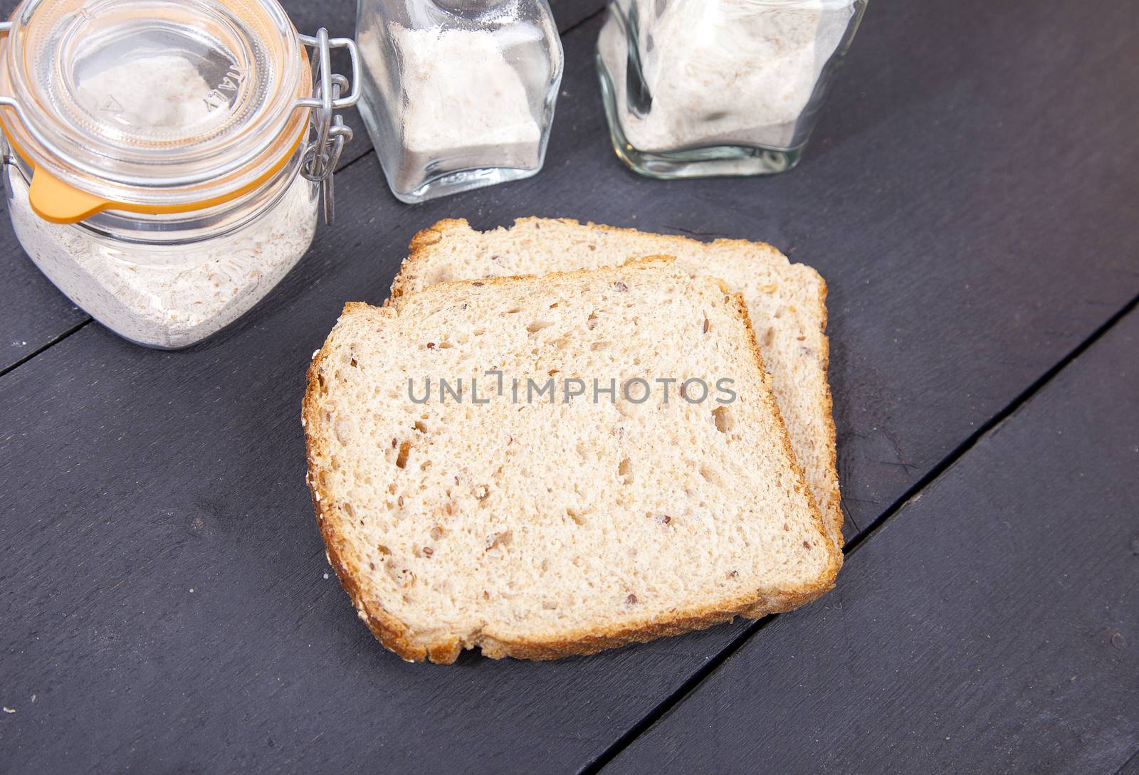 Gluten free bread with spelled flower on black wooden background