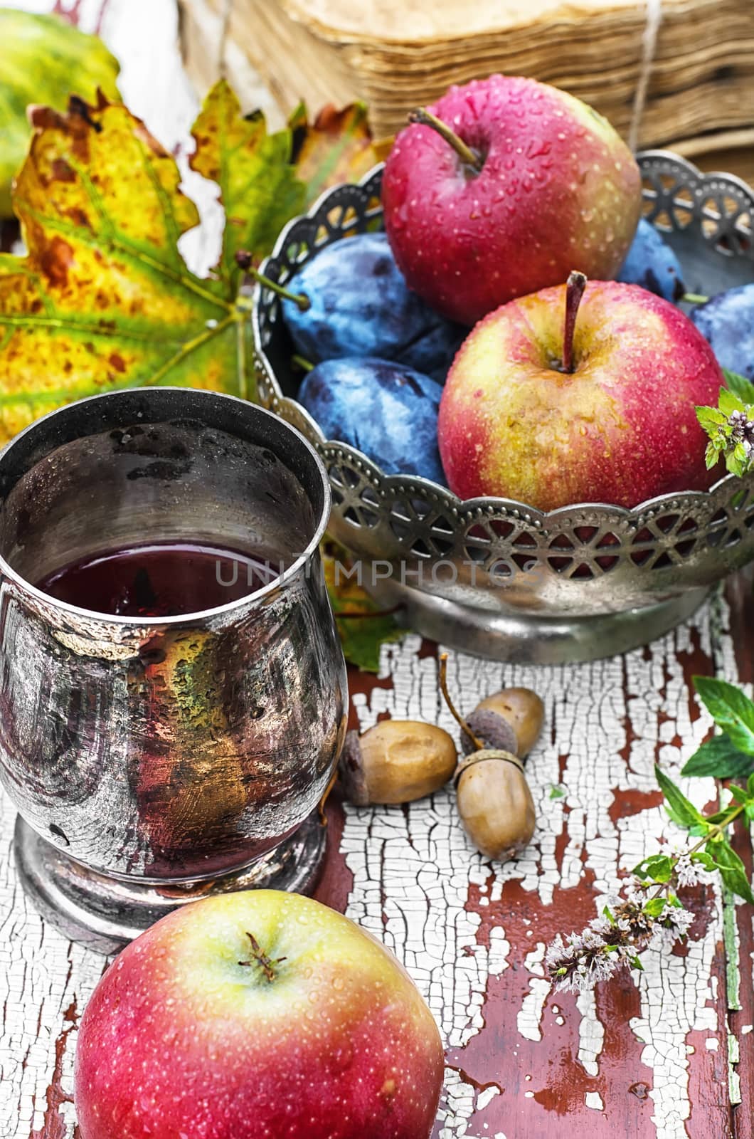 mug with herbal tea on  background of apples and plums in the autumn garden.Selective focus