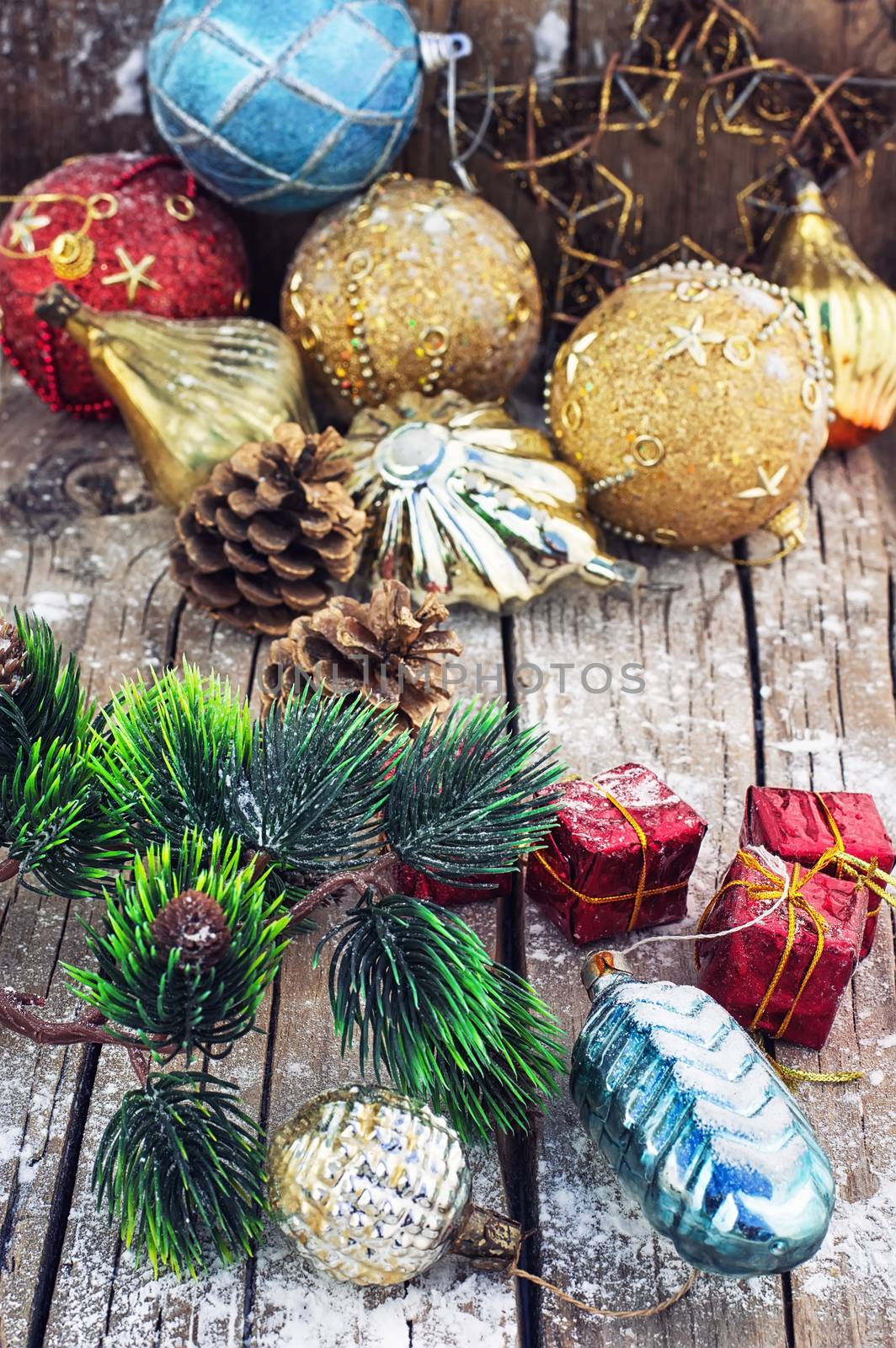 Christmas decorations under the branches of fir tree on  snowy wood plank