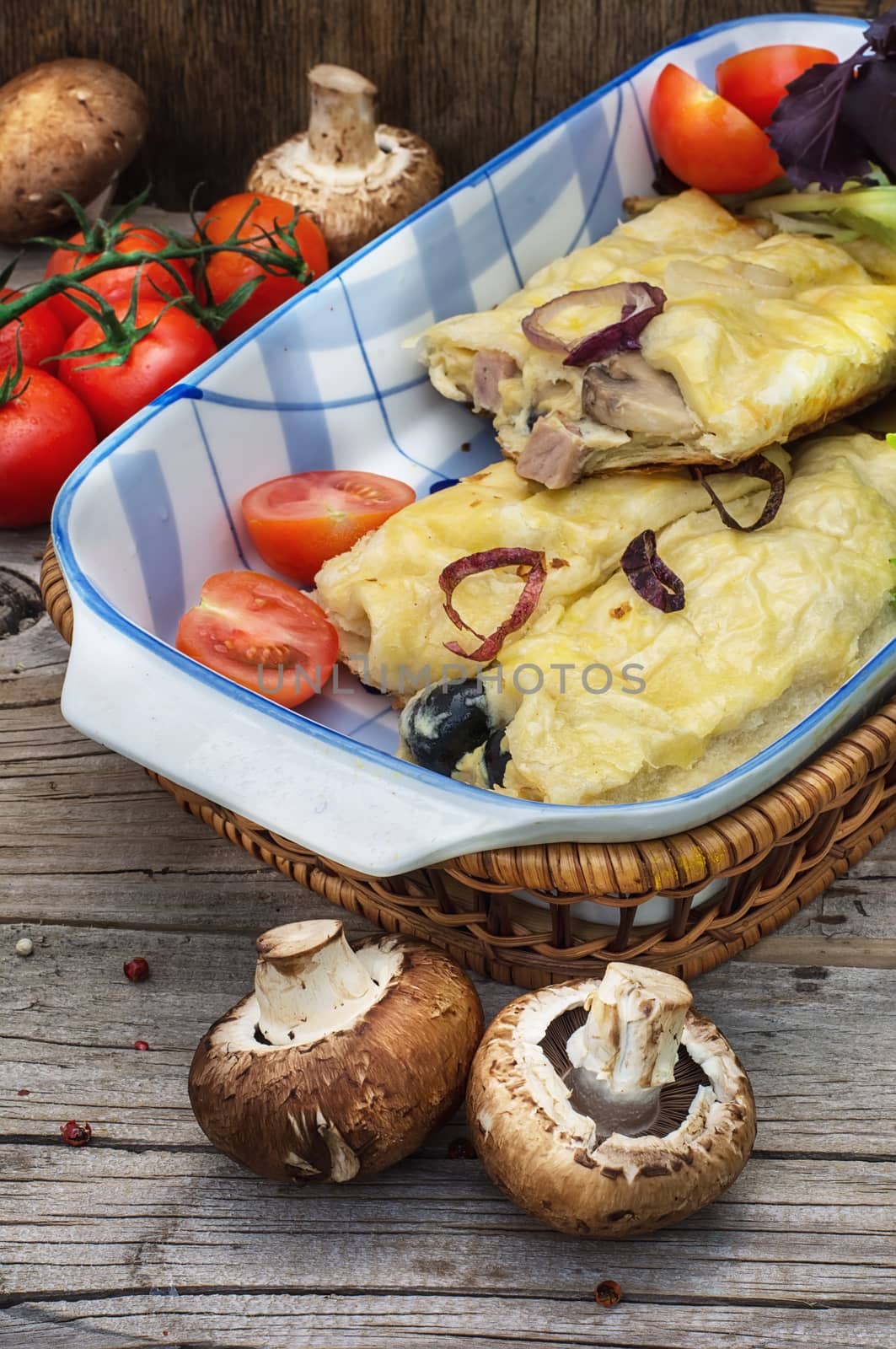 Pizza is of irregular shape elongated in length with fresh vegetables.Tinted