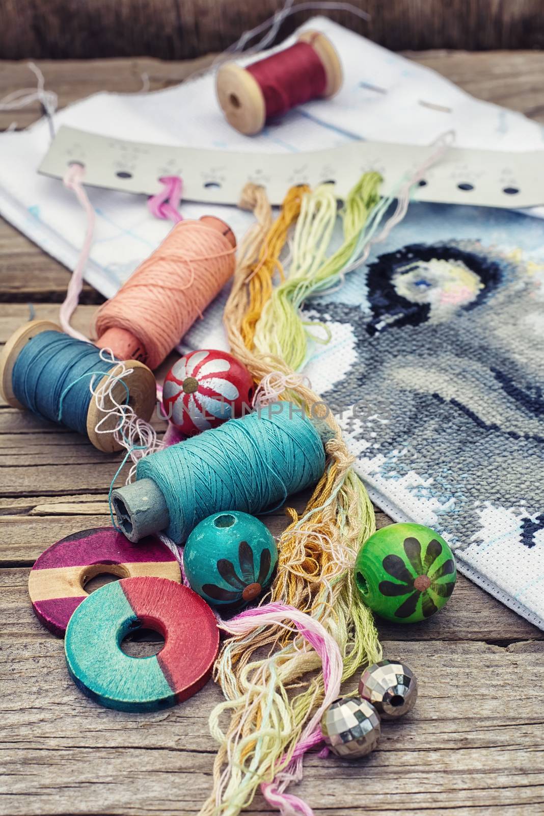 Yarn and thread for embroidering on cloth by hand on a wooden surface.Tinted