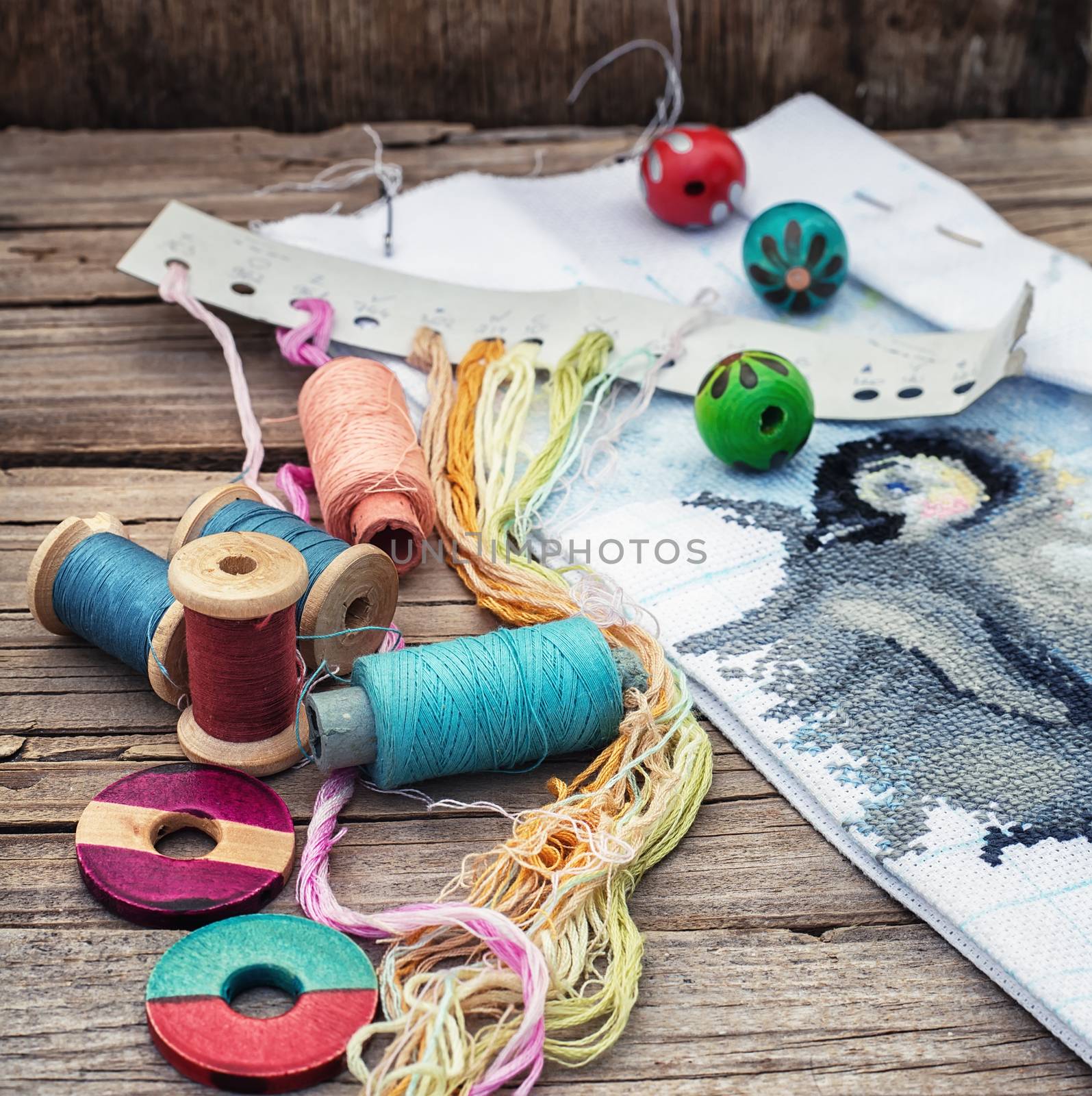 Yarn and thread for embroidering on cloth by hand on a wooden surface.Tinted