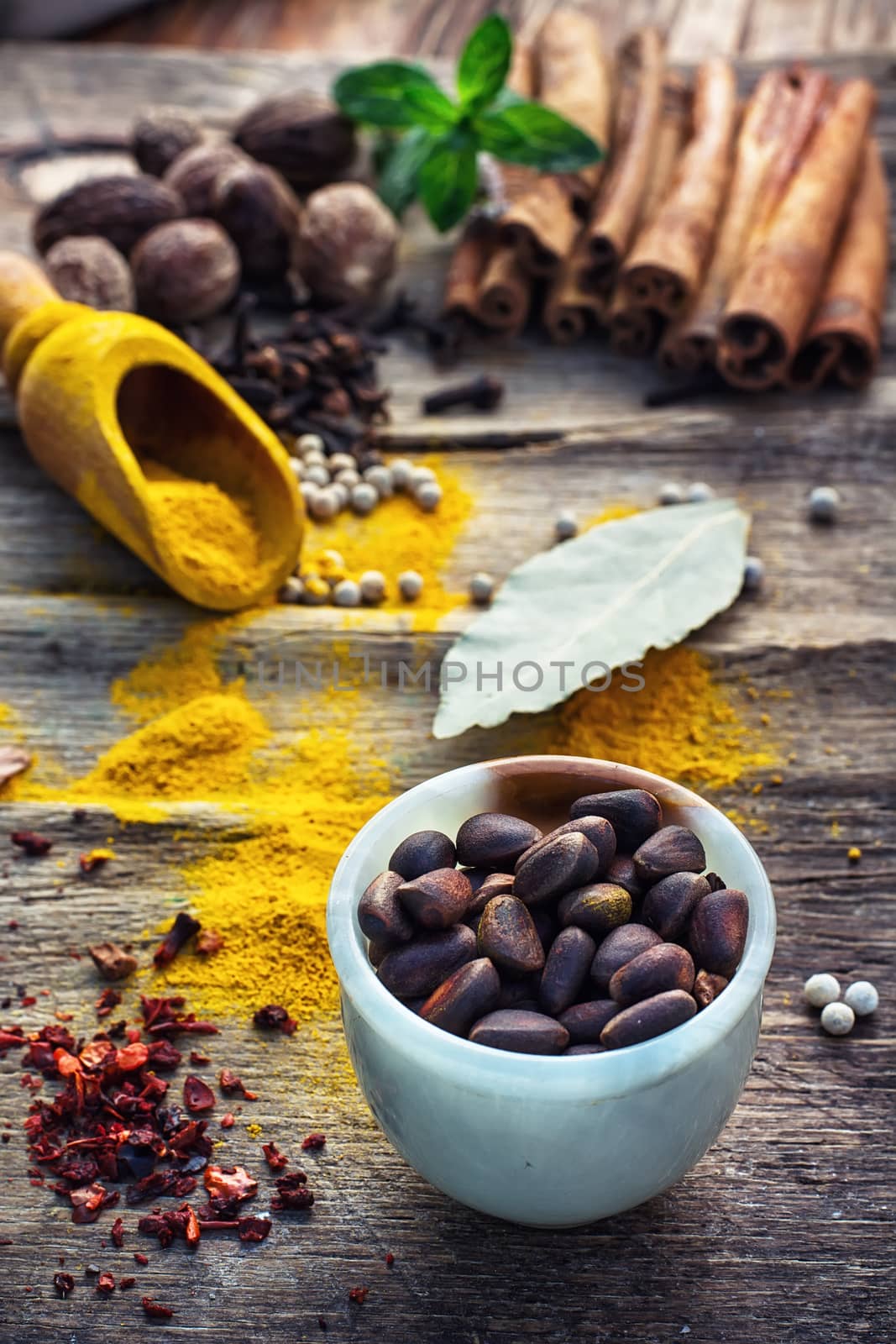 Seasoning with spices in wooden spoons on wooden table in rustic style.Pepper,cinnamon,cloves and mint