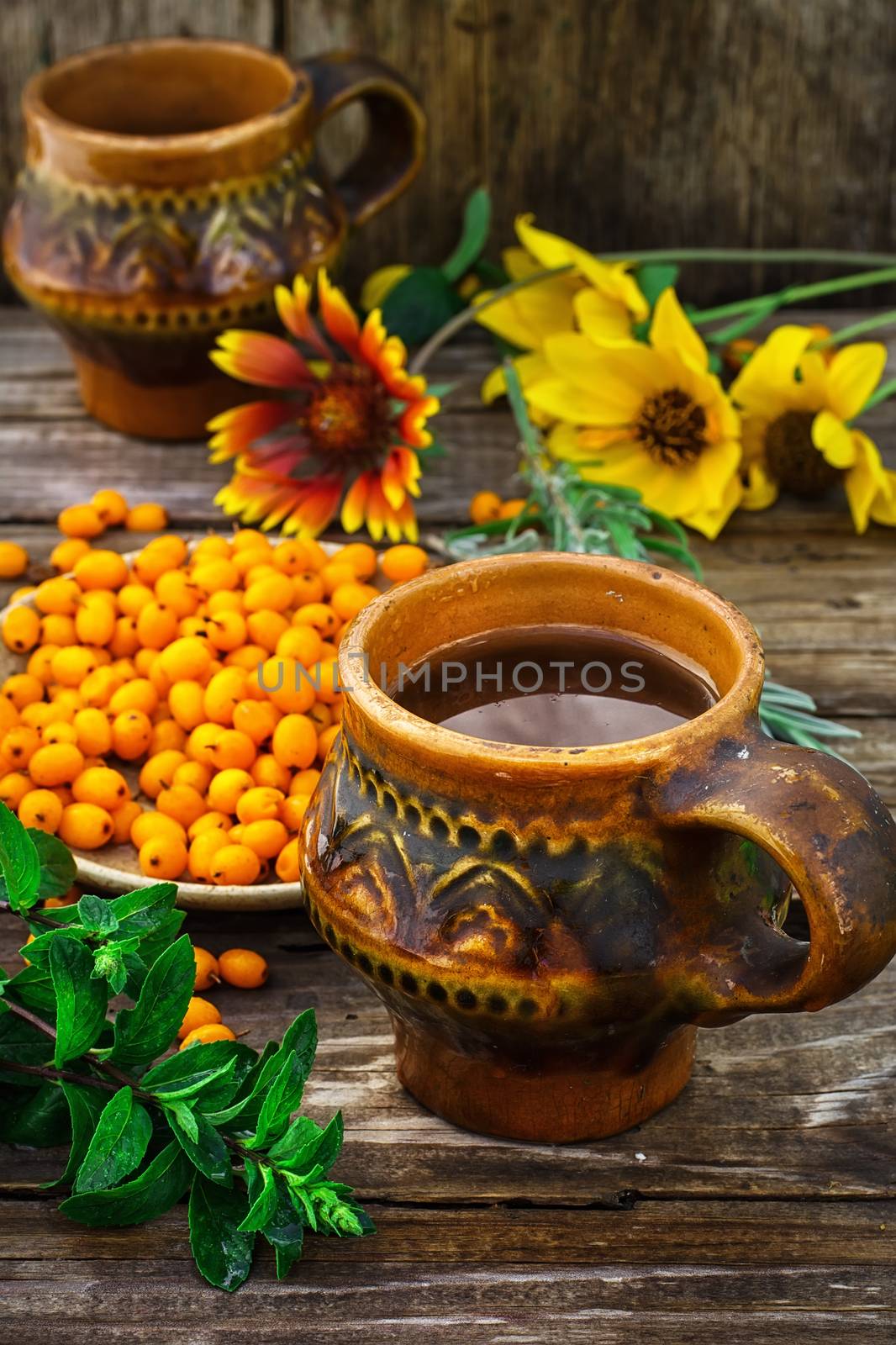 Ripe berries of sea buckthorn in  saucer on wooden background
