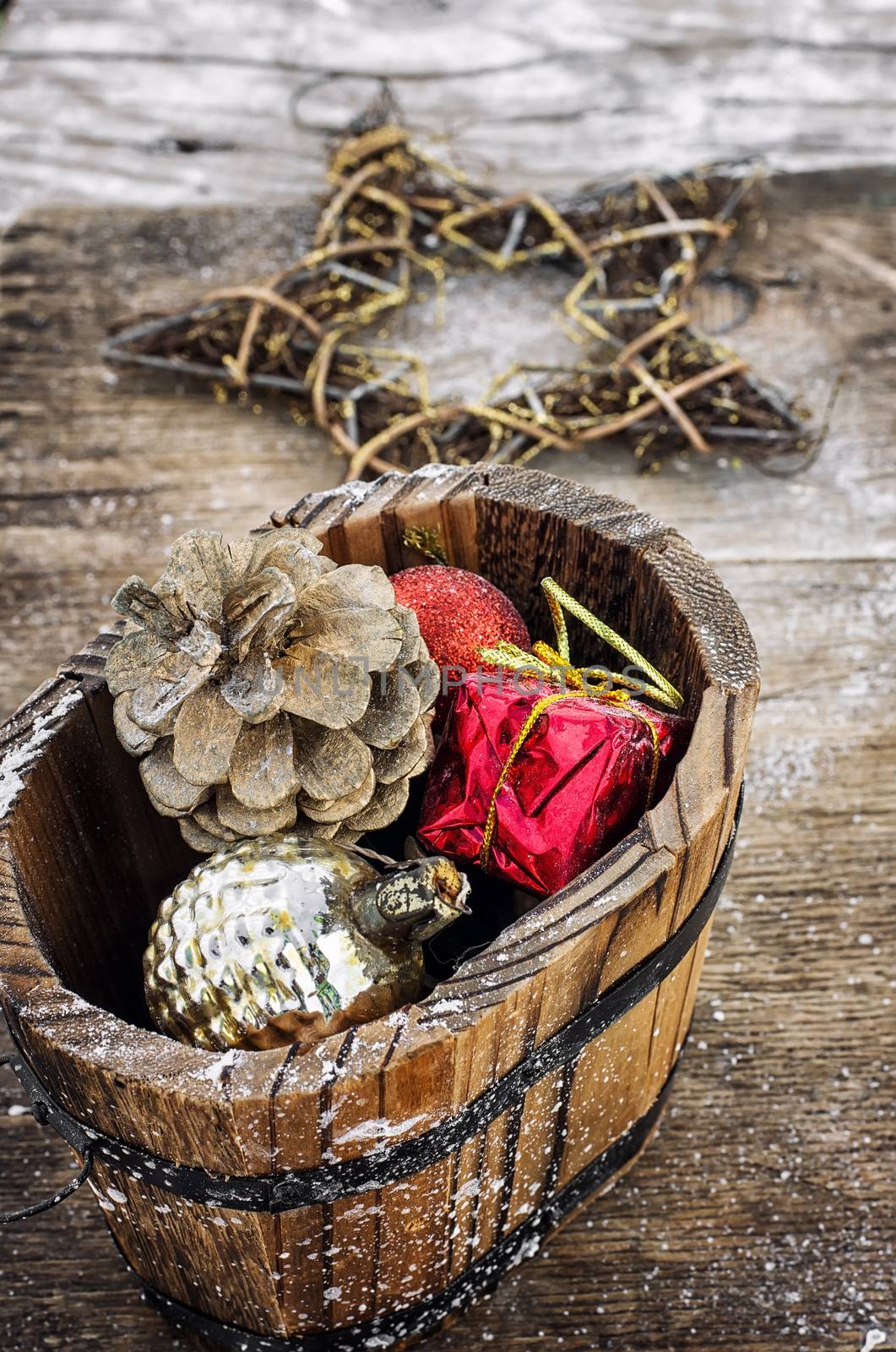 Decorative wooden tub filled with Christmas ornaments and pine cones