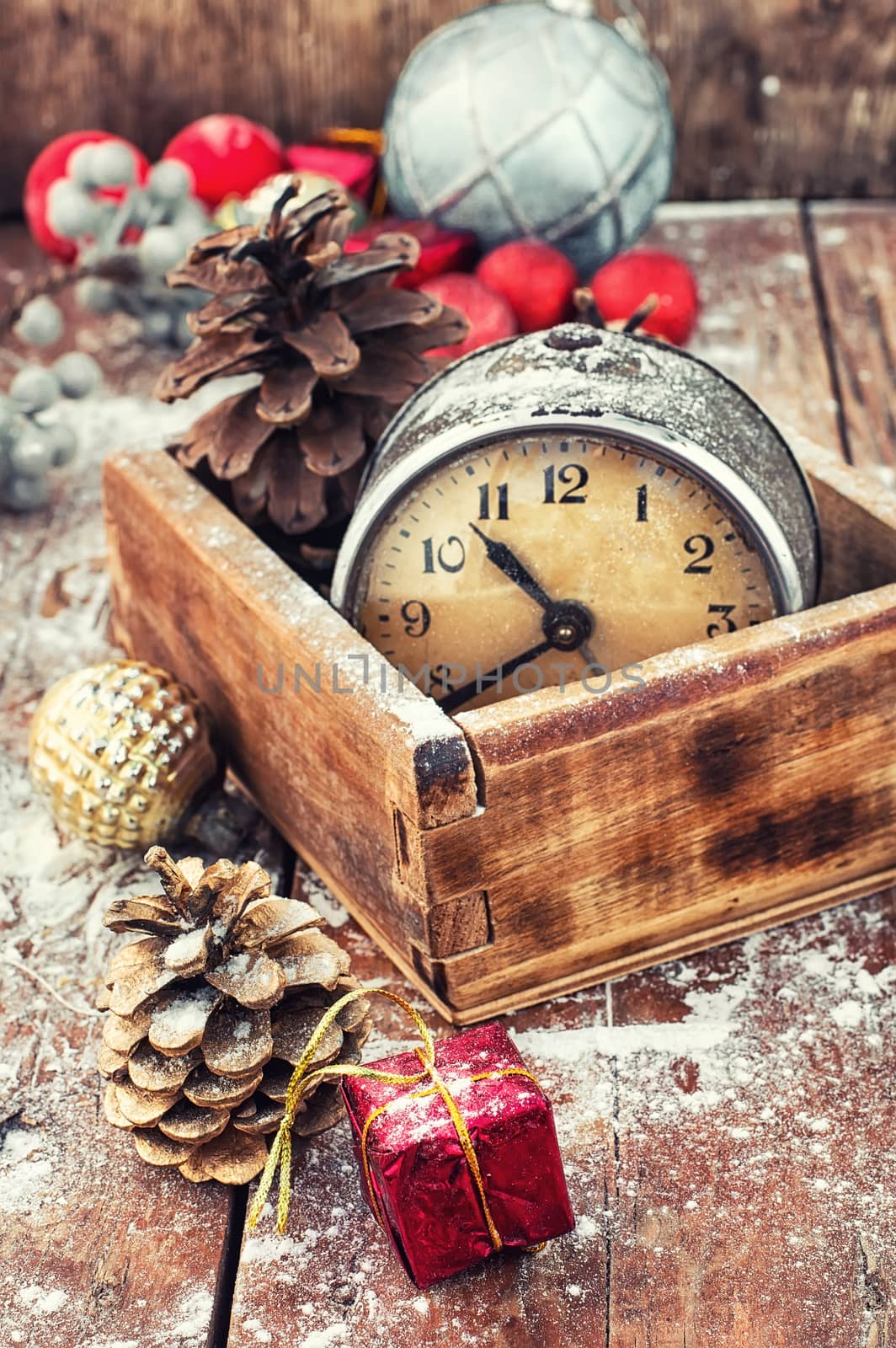 outdated watch in wooden box on the background of Christmas decorations and pine cones.