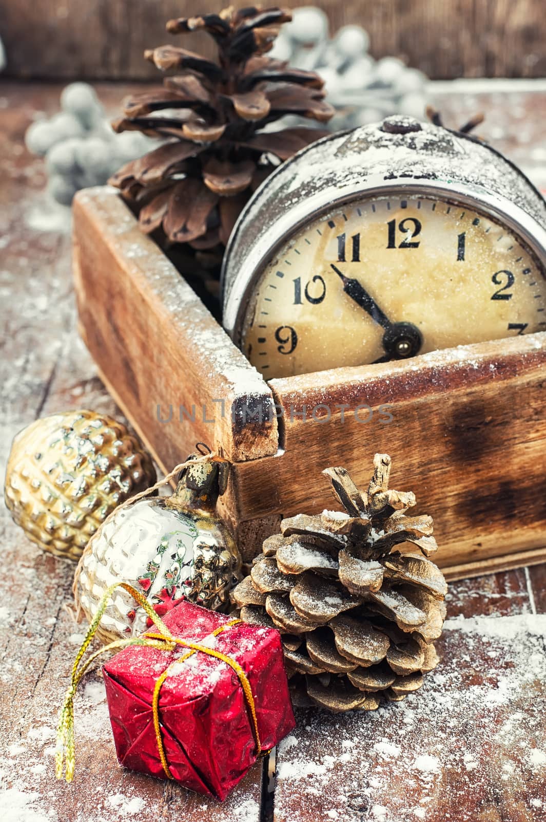 outdated watch in wooden box on the background of Christmas decorations and pine cones.
