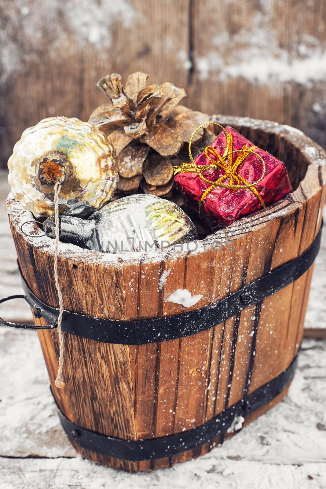 Decorative wooden tub filled with Christmas ornaments and pine cones