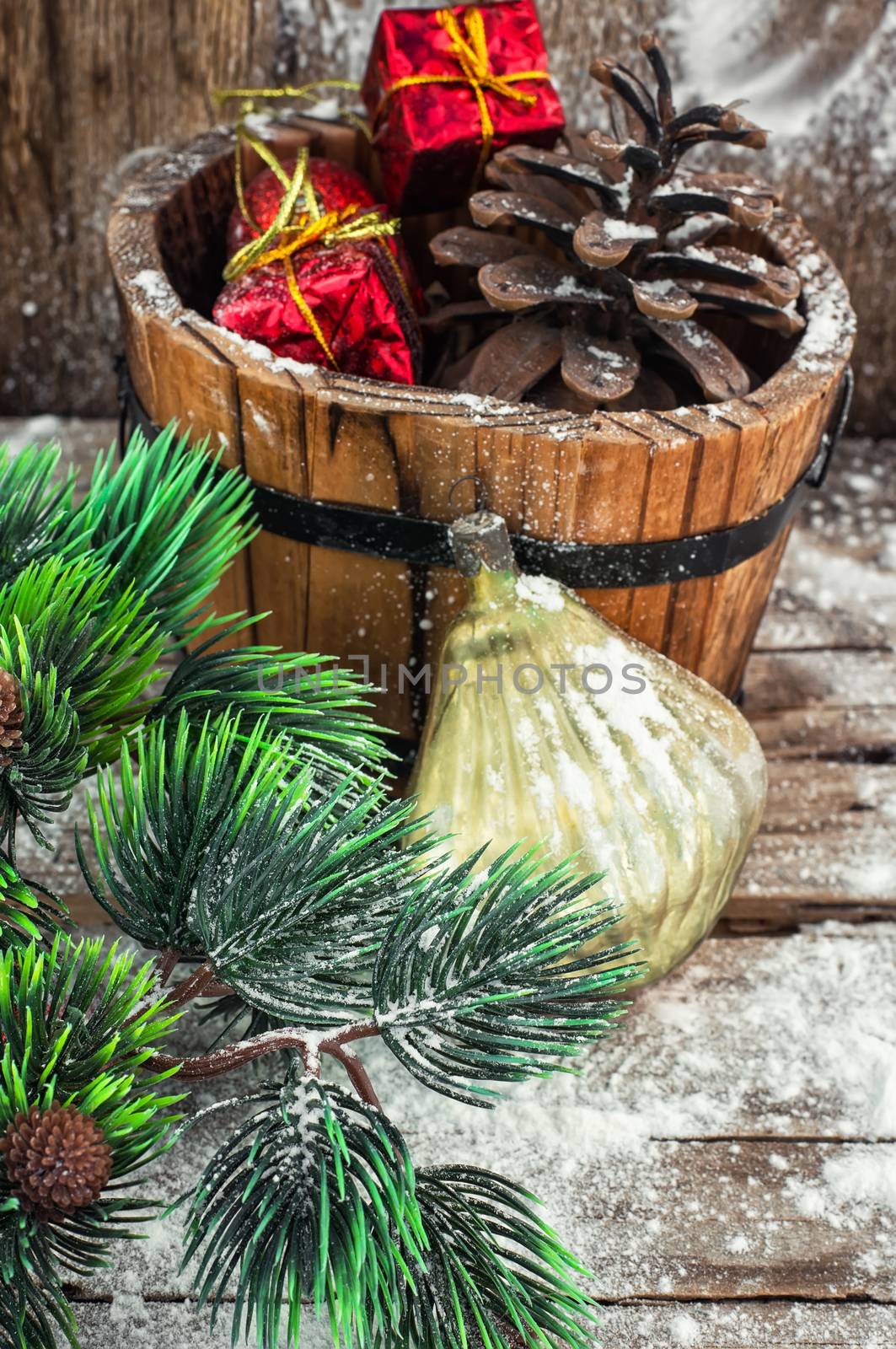 Decorative wooden tub filled with Christmas ornaments and pine cones