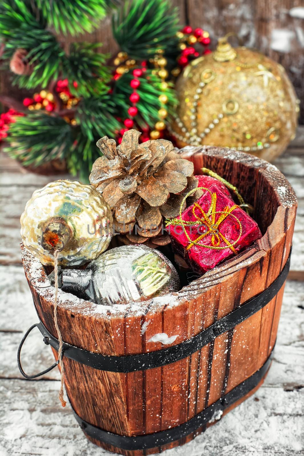 Decorative wooden tub filled with Christmas ornaments and pine cones