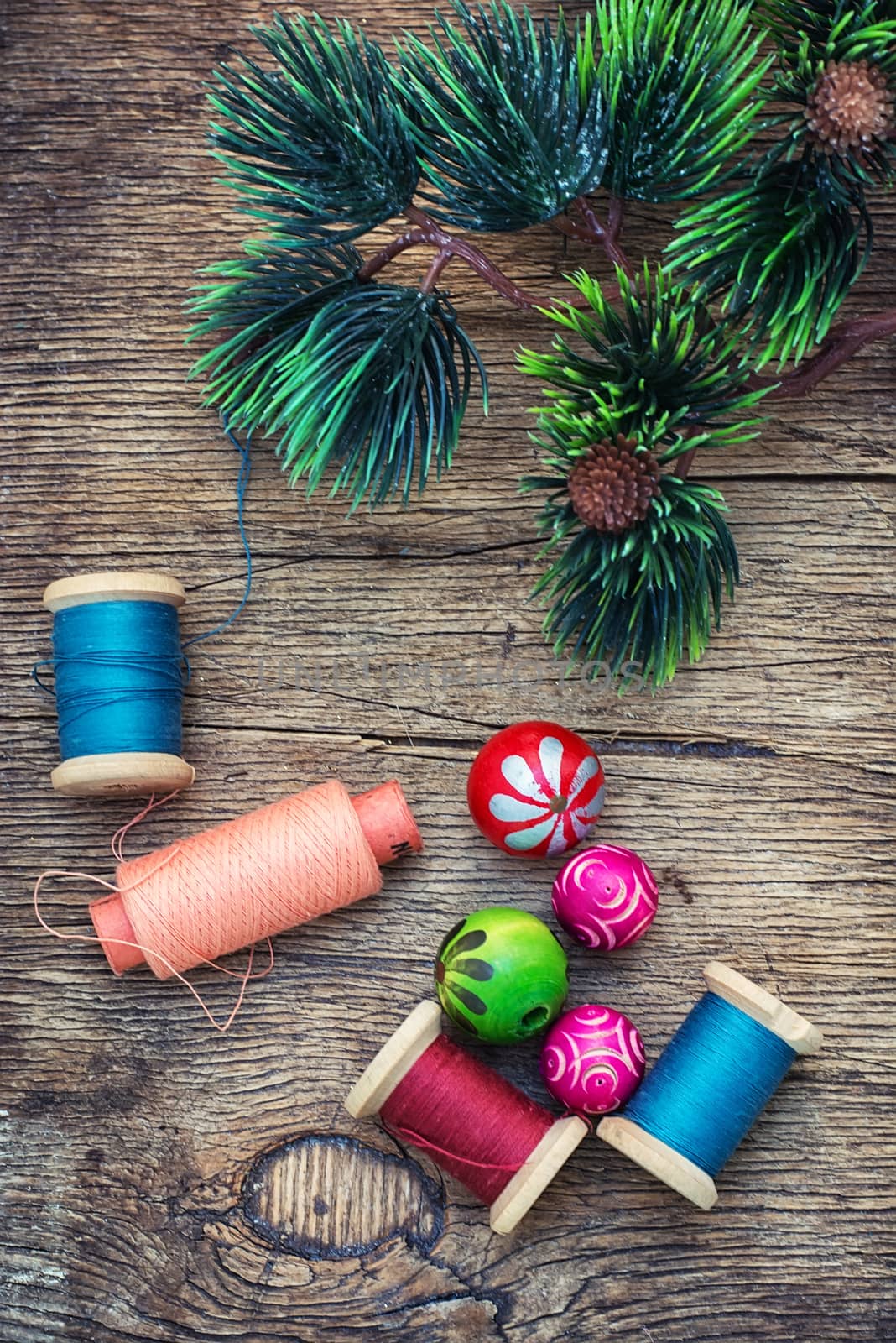 spool of thread and Christmas decorations on wooden background
