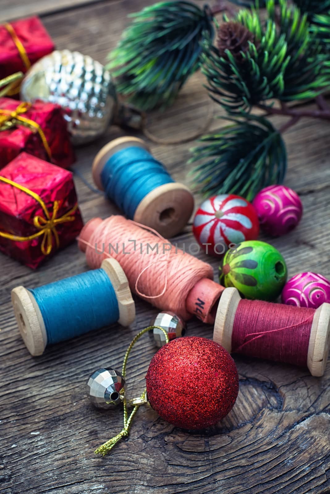 spool of thread and Christmas decorations on wooden background