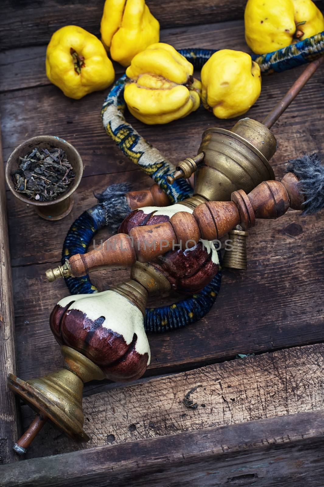 Stylish hookah disassembled in wooden box with fragrant autumn fruit quince.