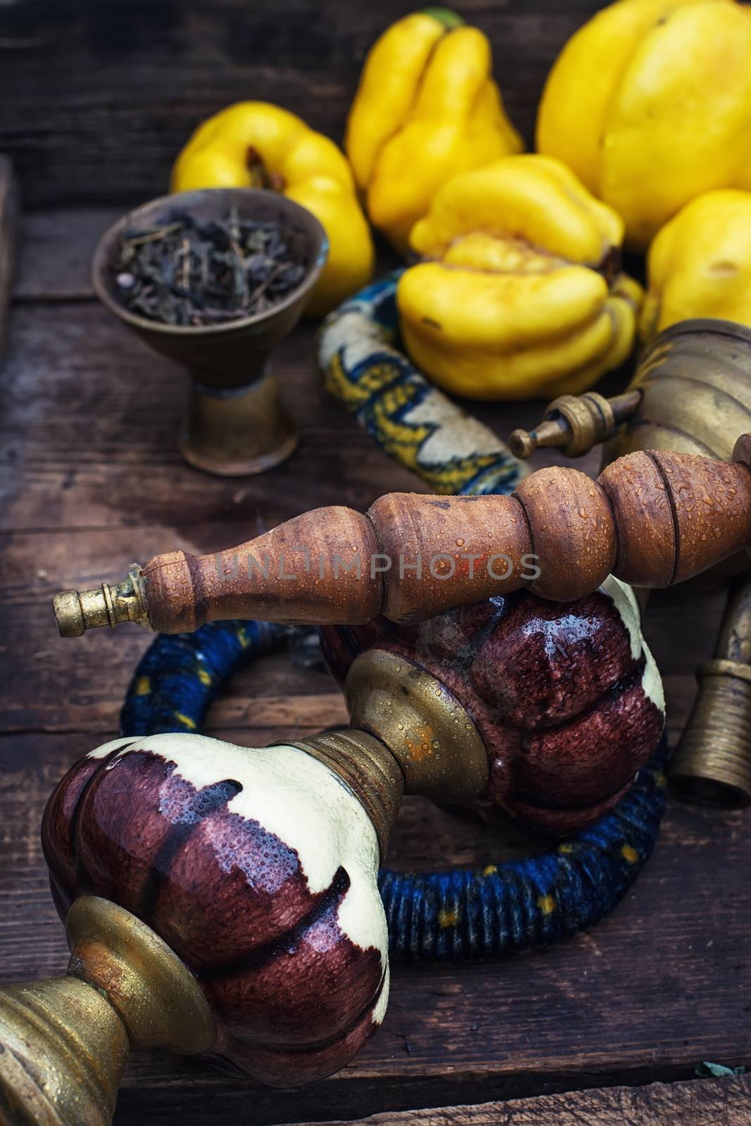 Stylish hookah disassembled in wooden box with fragrant autumn fruit quince.