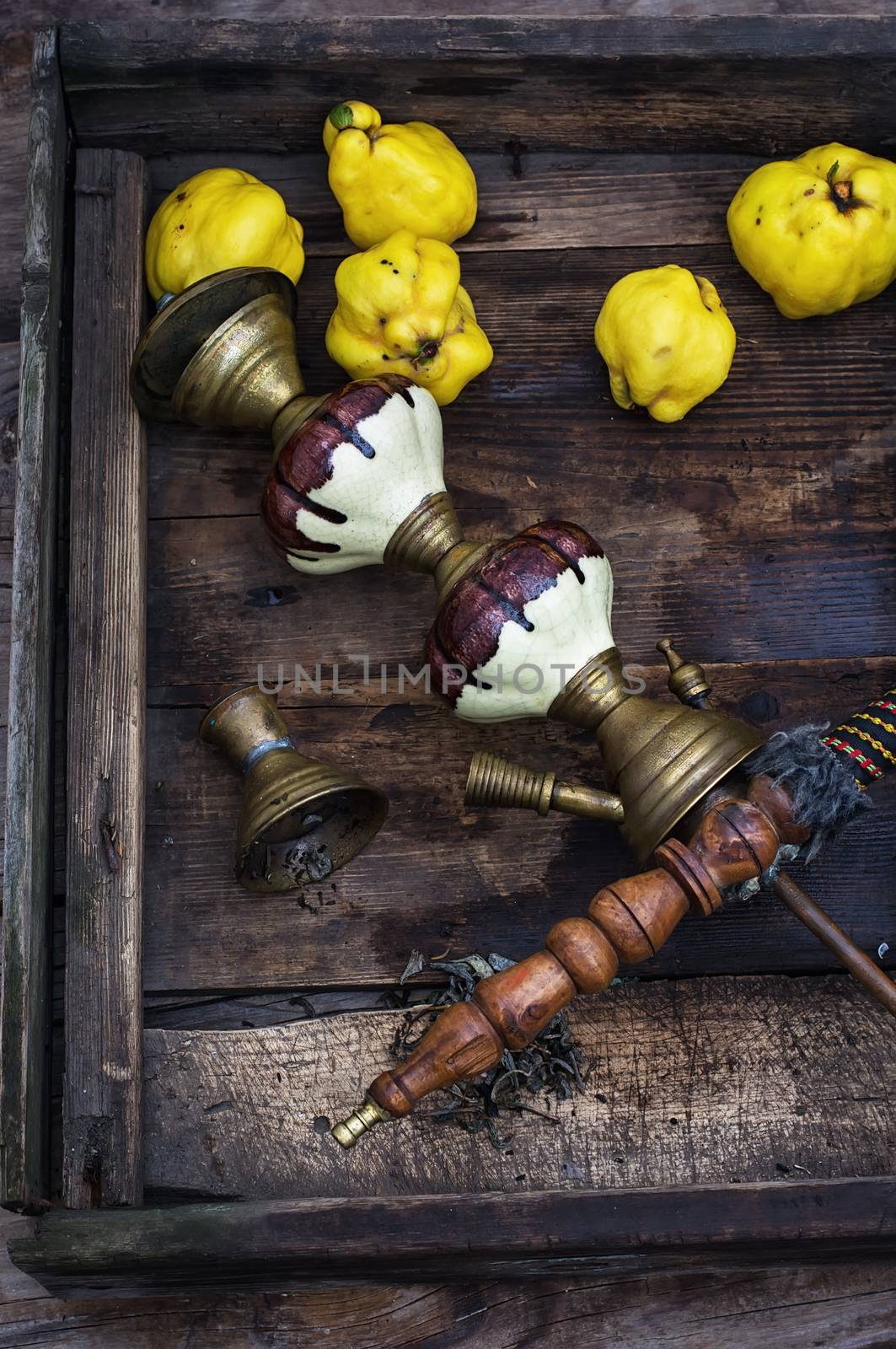 Stylish hookah disassembled in wooden box with fragrant autumn fruit quince.