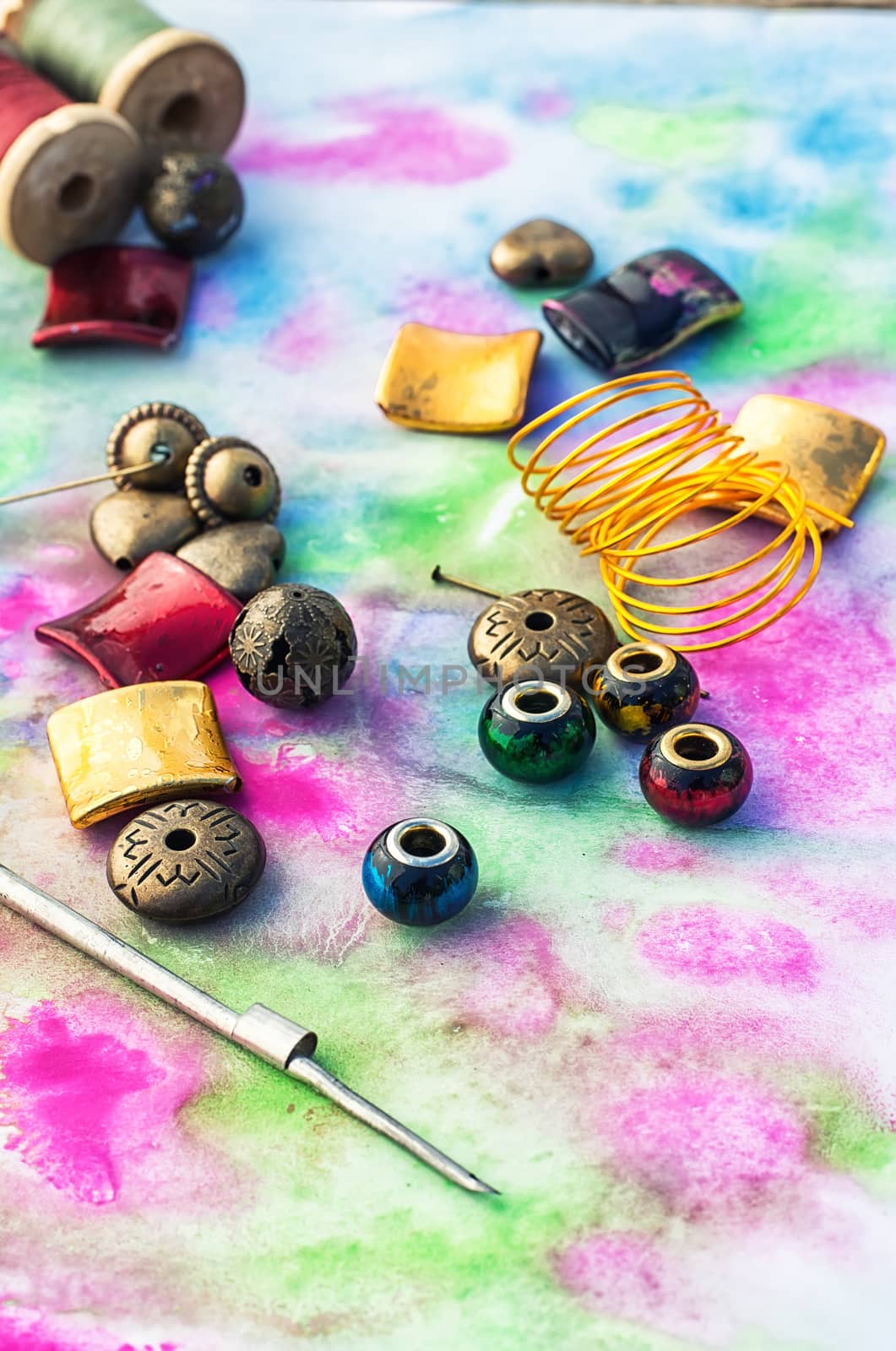Beads and tools for needlework on bright background