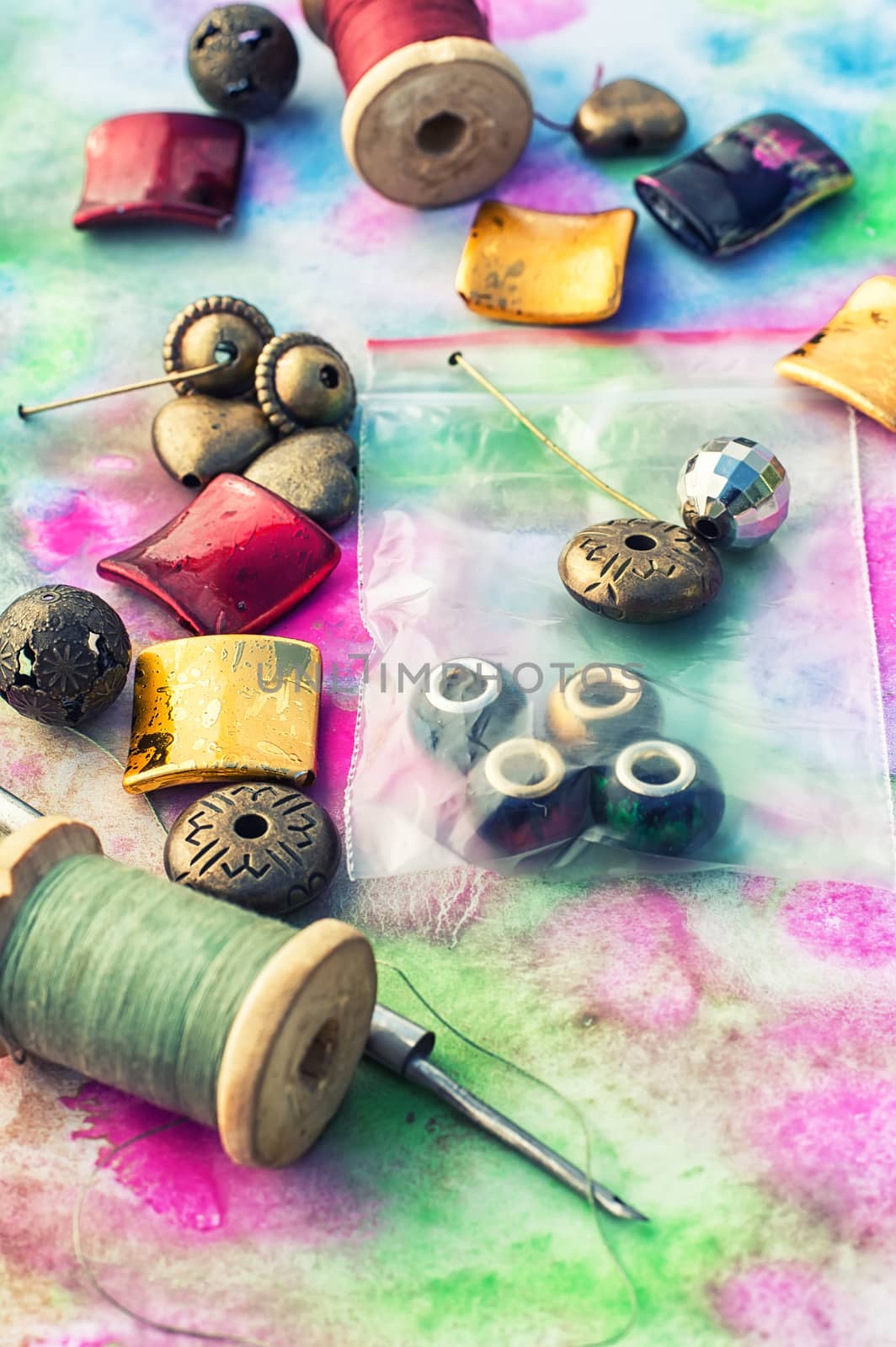 Beads and tools for needlework on bright background