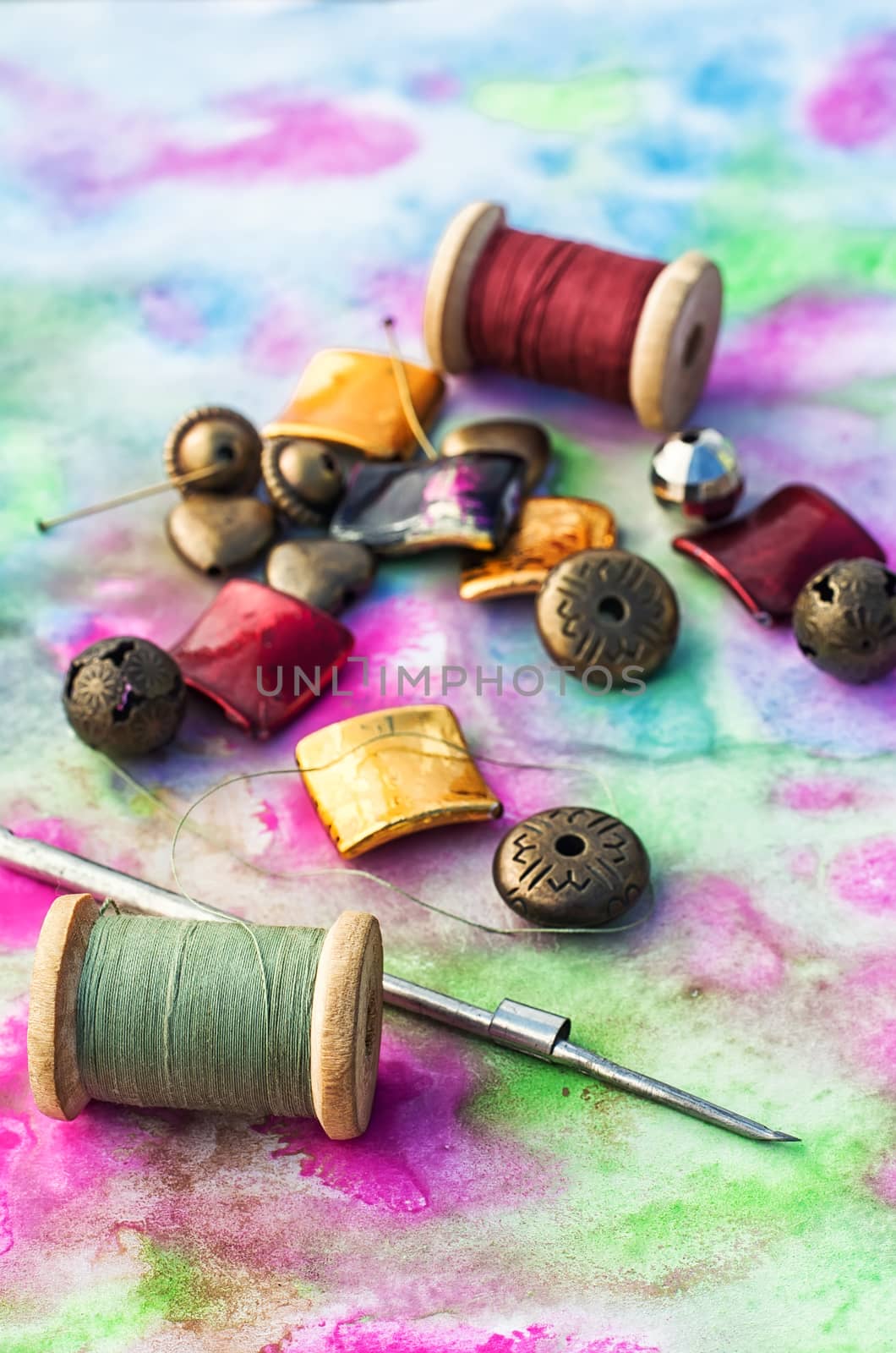 Beads and tools for needlework on bright background