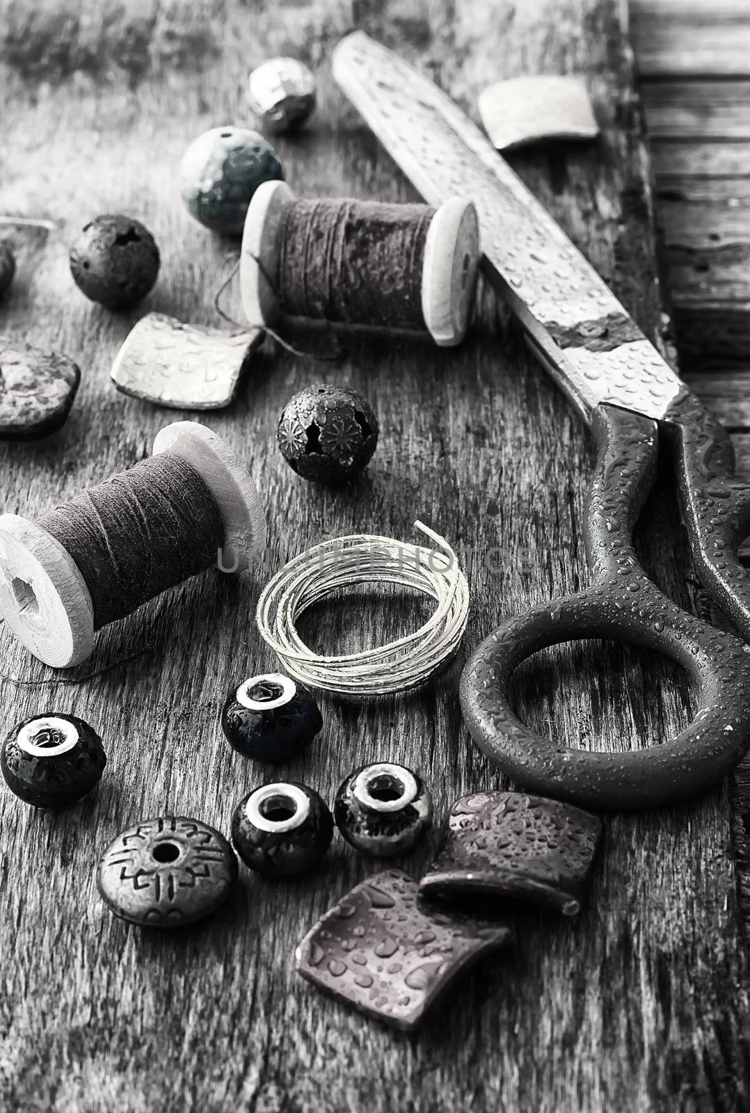 outdated tools and jewelry for needlework on wooden background
