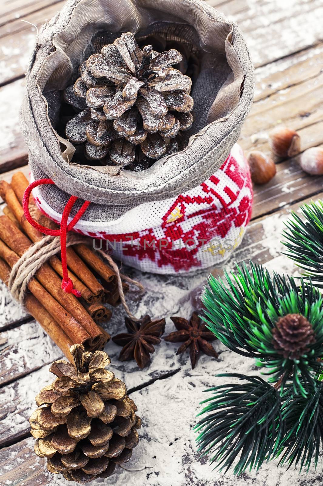 Christmas bag with pine cones on wooden snowy background