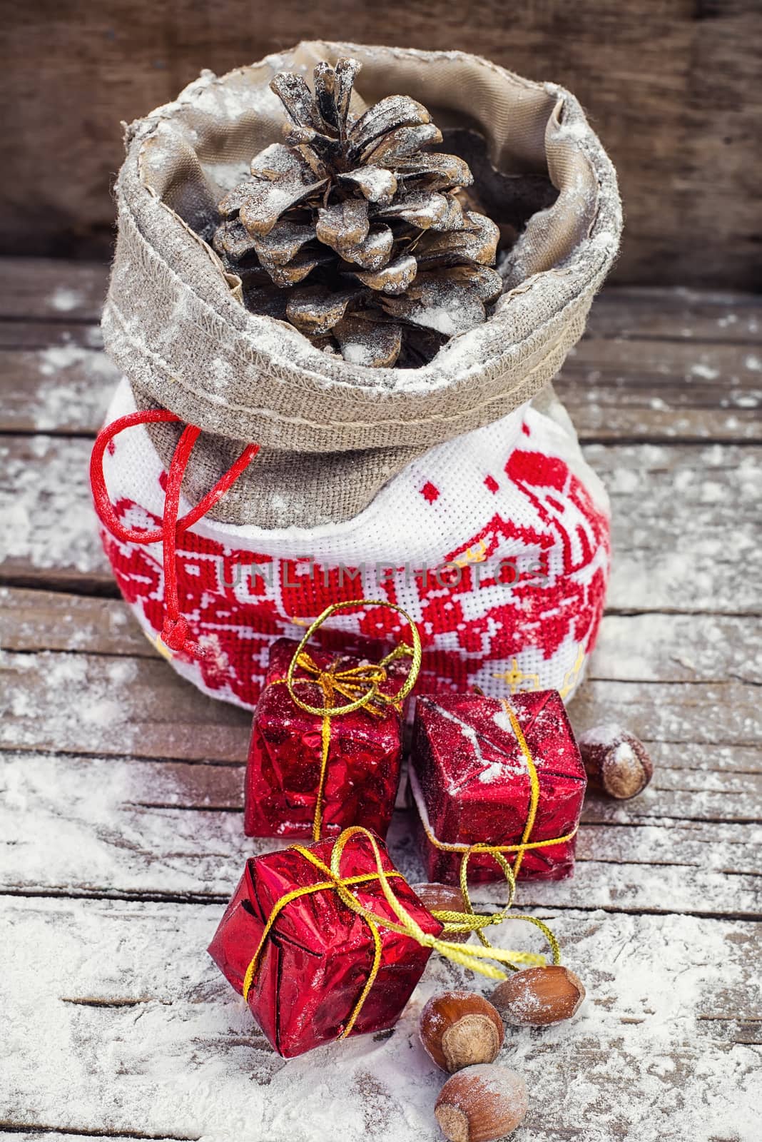 Symbolic Christmas bag with pine cones and three gift boxes