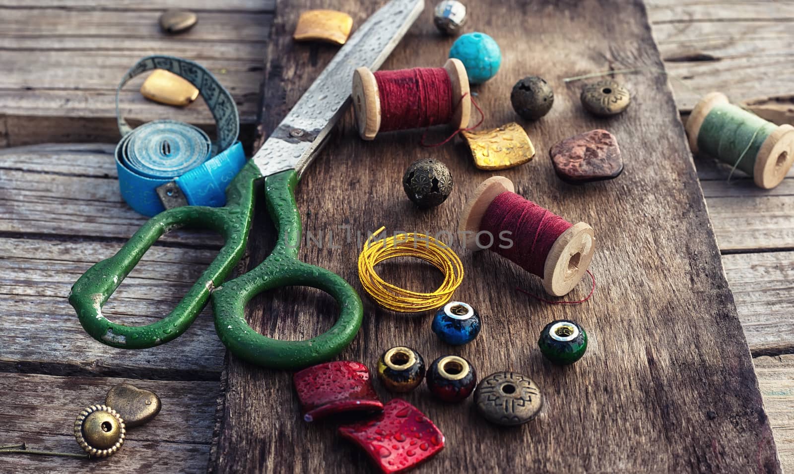 outdated tools and jewelry for needlework on wooden background