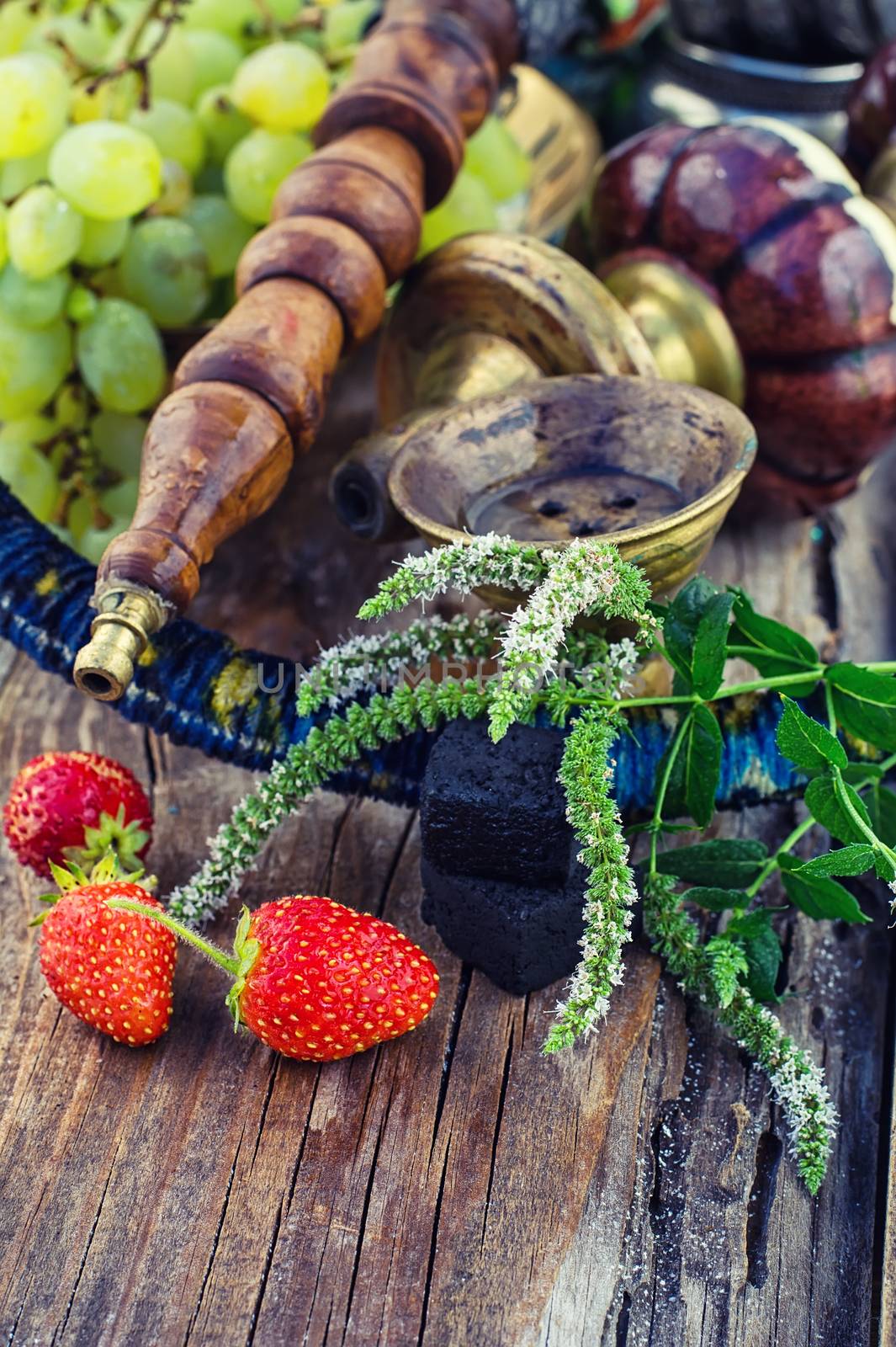 Hookah with fruit flavour on wooden table in vintage style