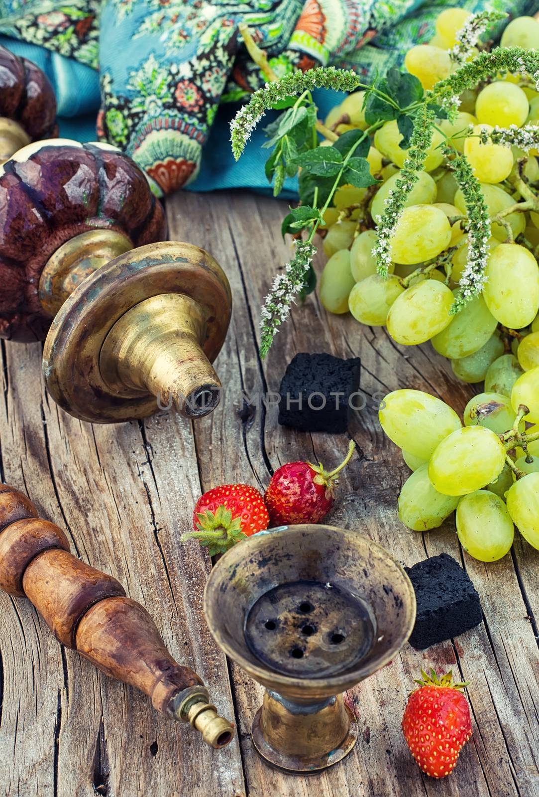 Hookah with fruit flavour on wooden table in vintage style