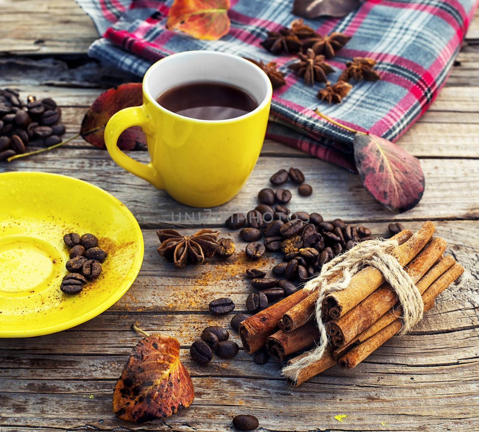 Yellow cup of black coffee on background  with autumn leaves