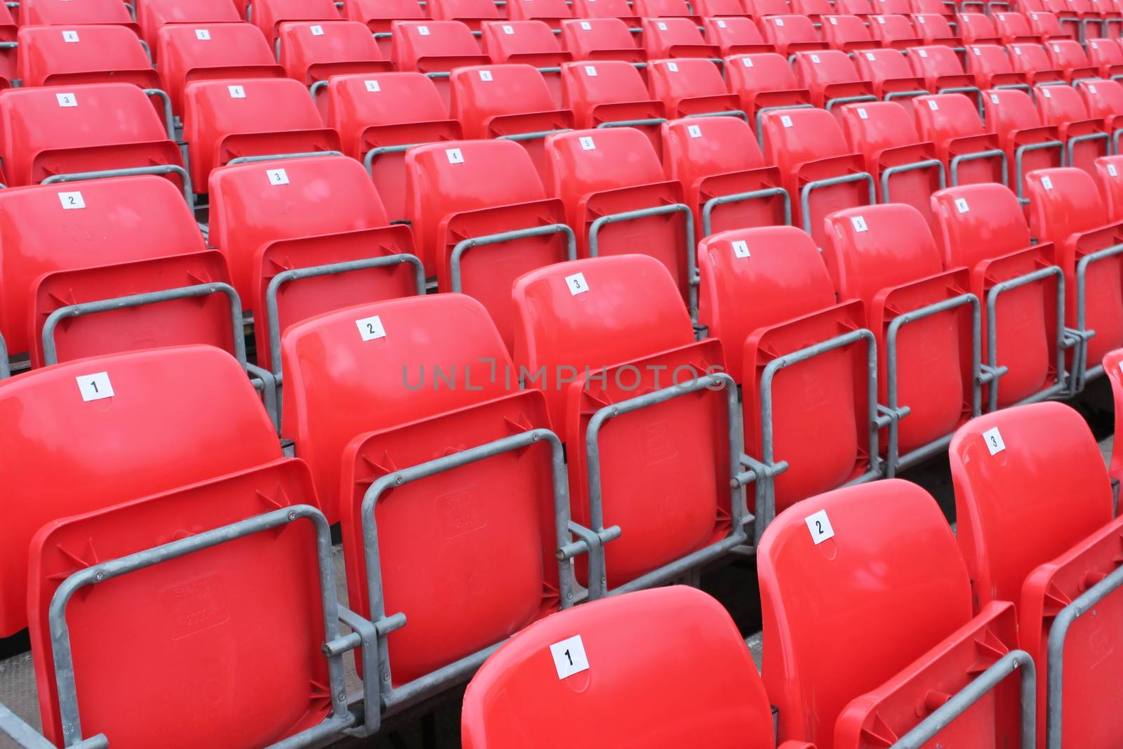 Empty red folding seats in stadium rows