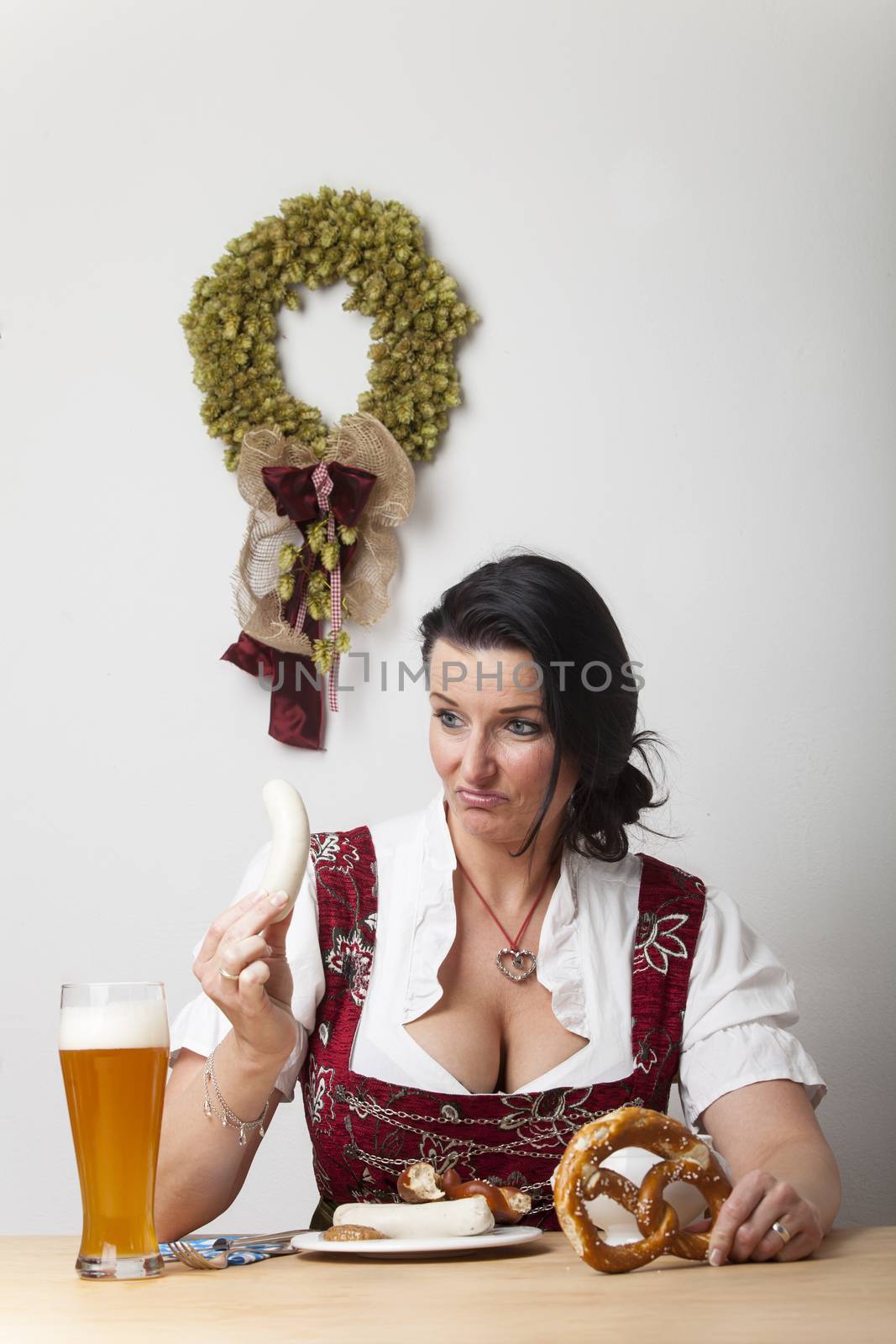 bavarian woman in a dirndl with sausages by bernjuer