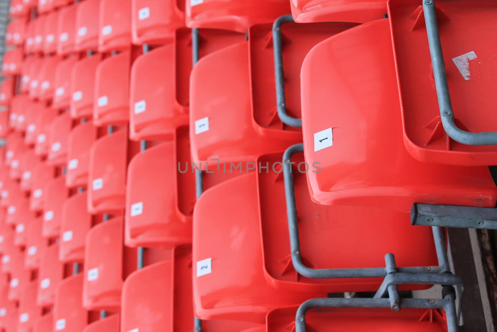 Empty red seats in stadium by cheekylorns