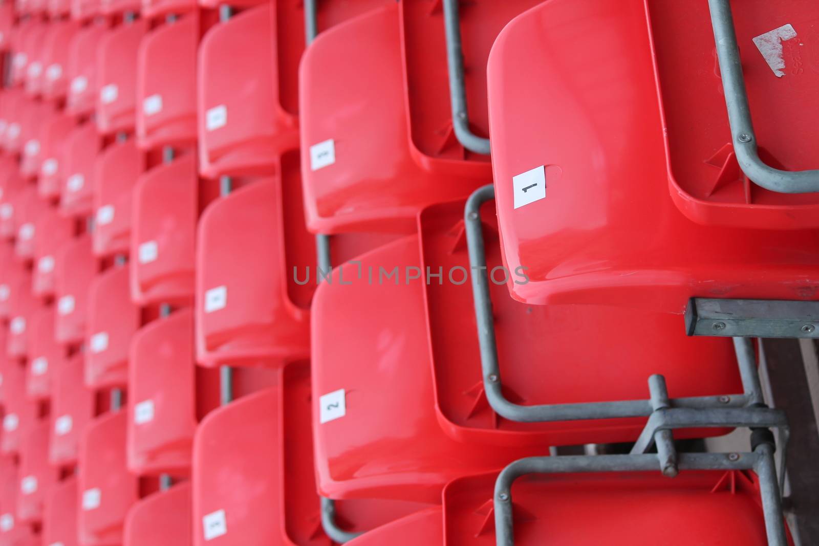 Empty red seats in stadium by cheekylorns