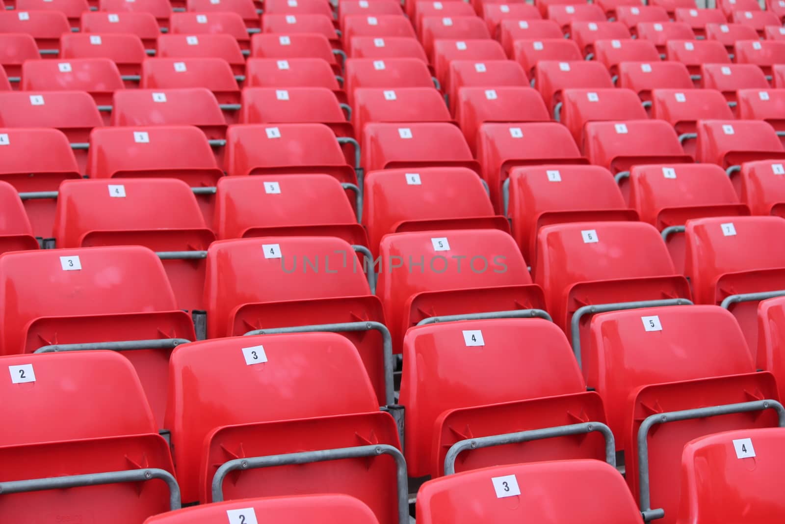 Empty red seats in stadium by cheekylorns