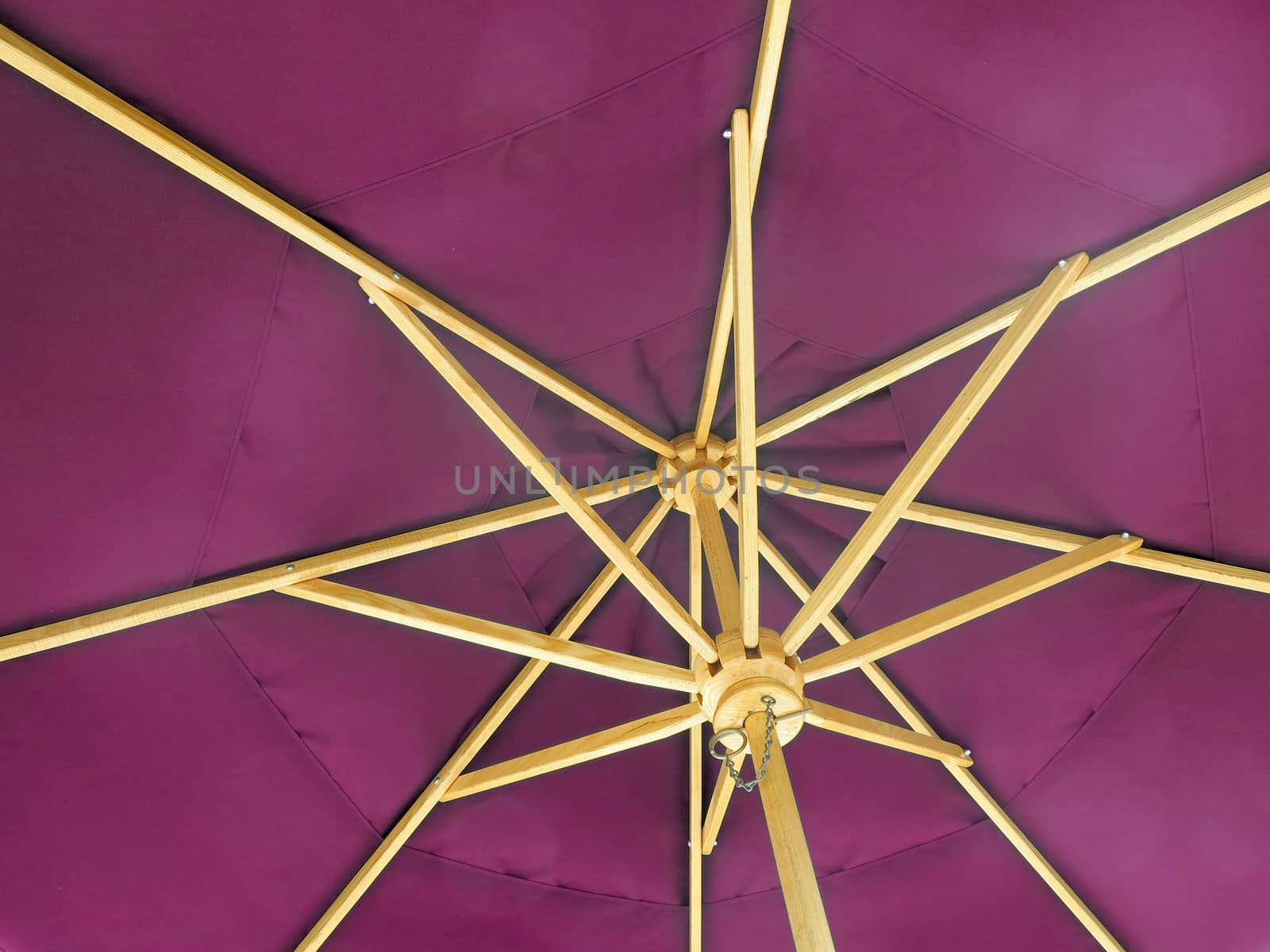 The inside of an open pink umbrella