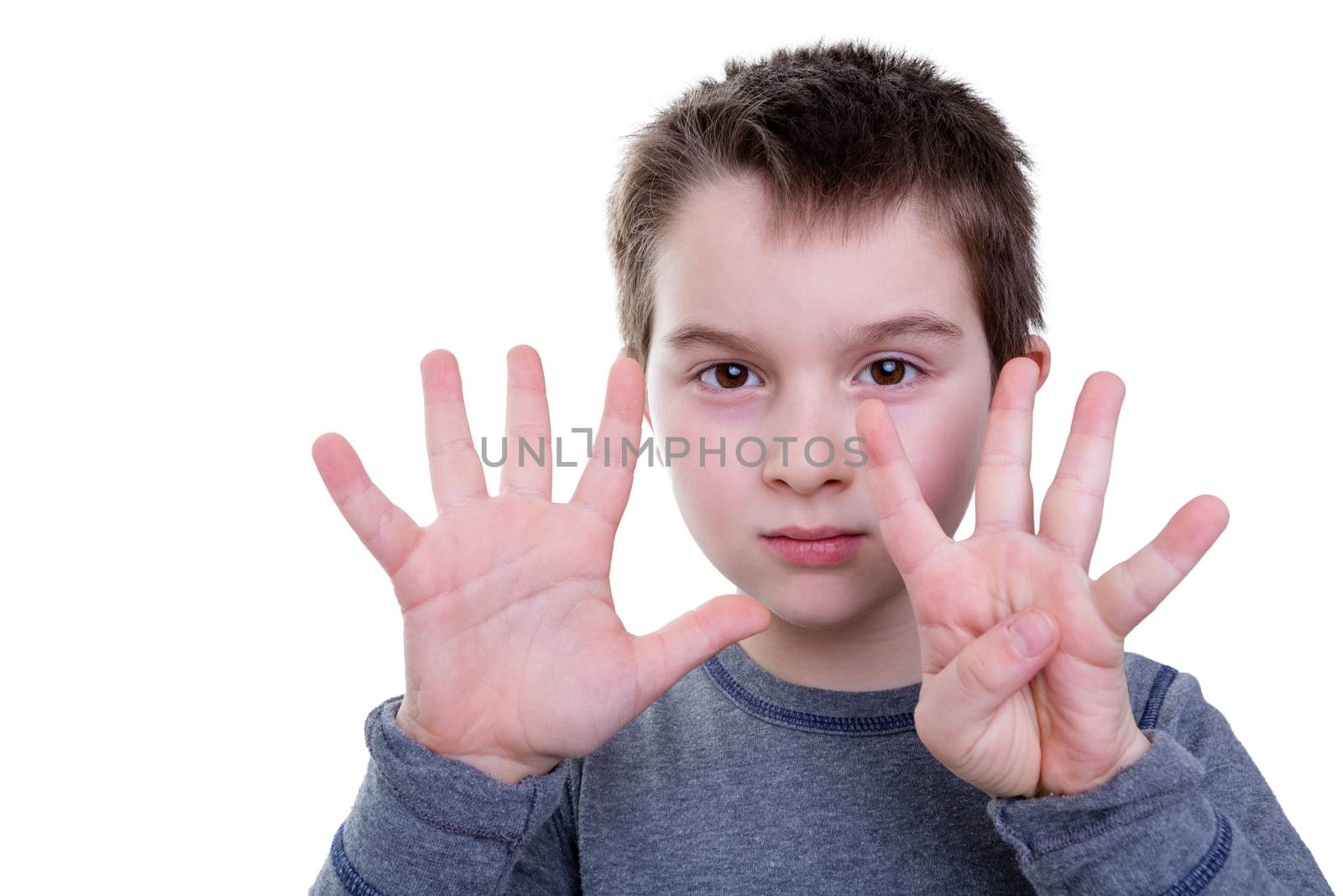 Cute serious little boy gesturing with eight fingers on two hands as if to count or display a symbol