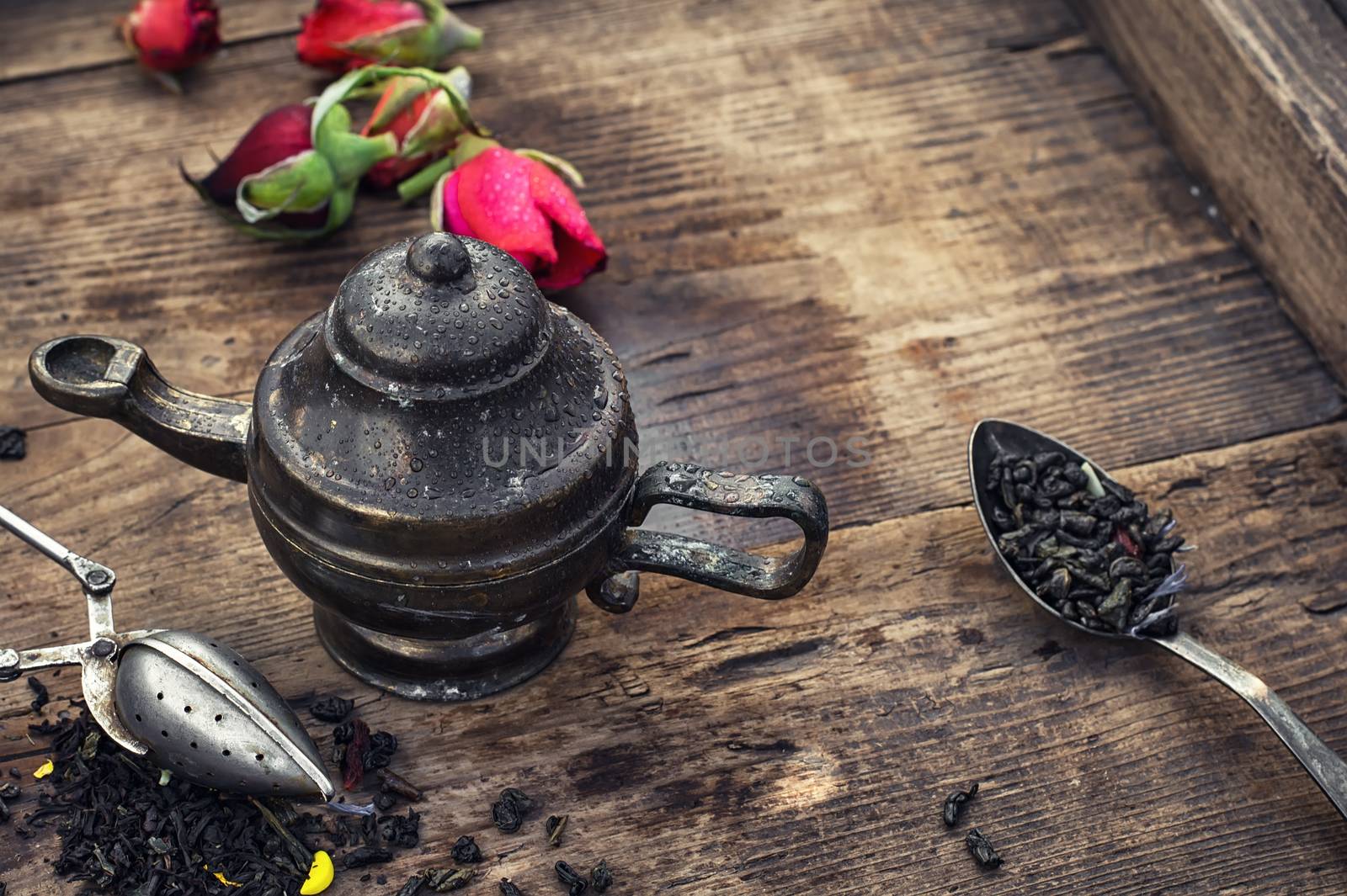 Stylish spoons with  variety of tea on vintage wooden board.