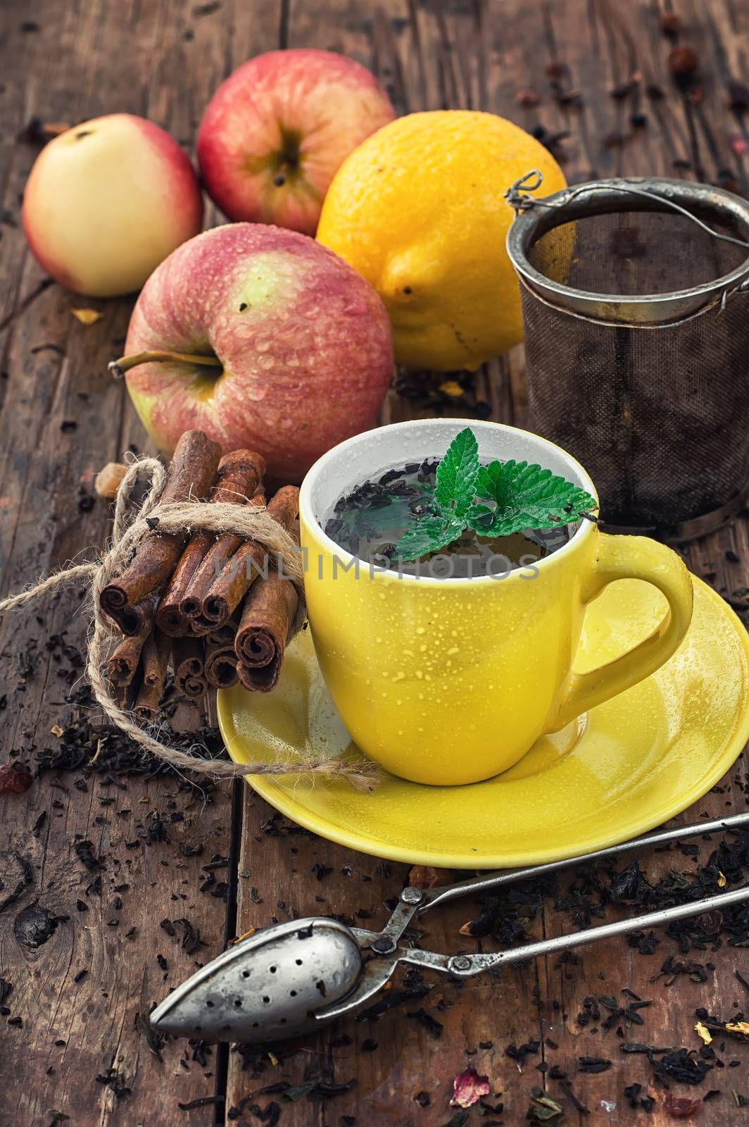 Apple tea with cinnamon on a background of custard spoons in the autumn style