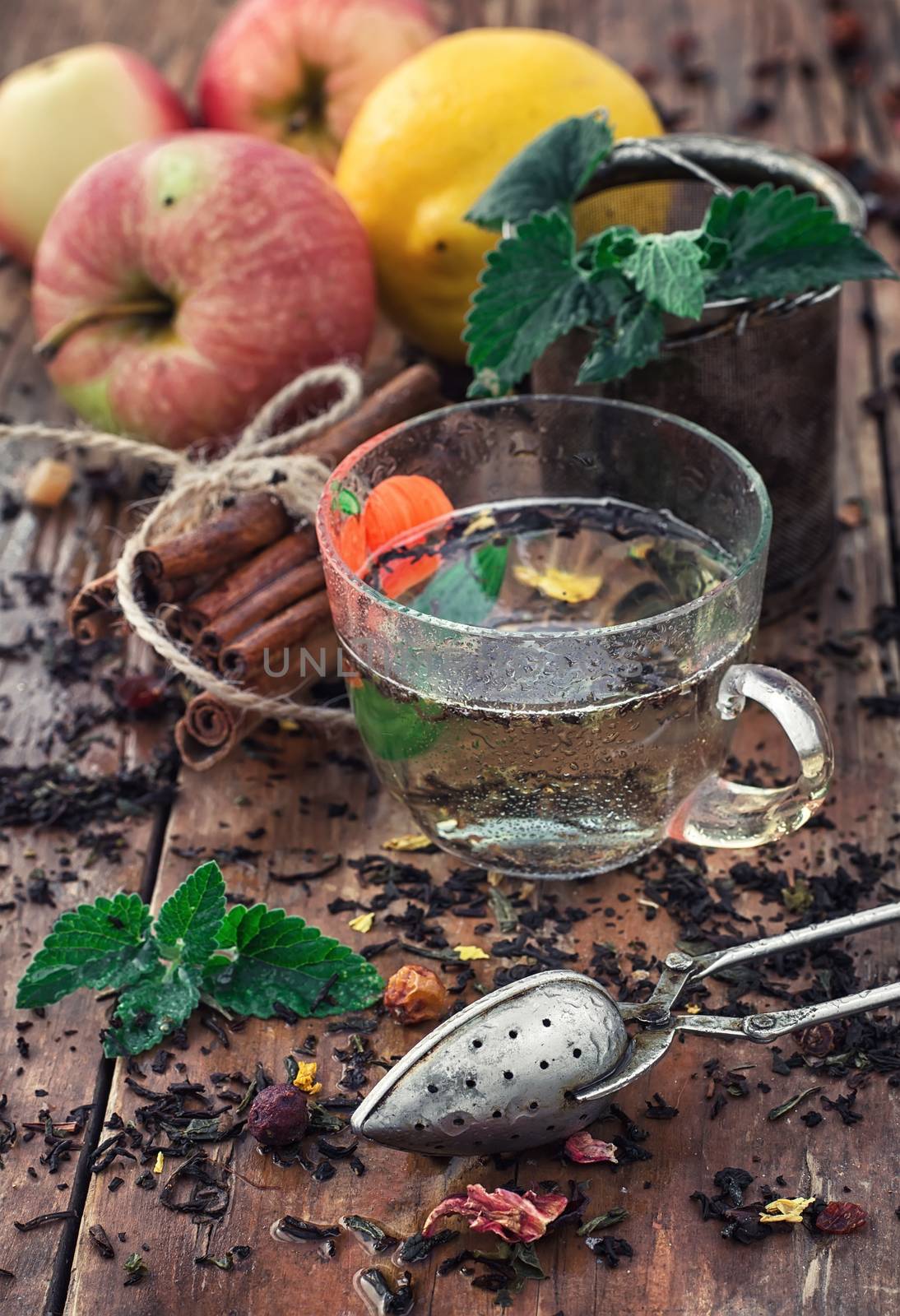 Apple tea with cinnamon on a background of custard spoons in the autumn style