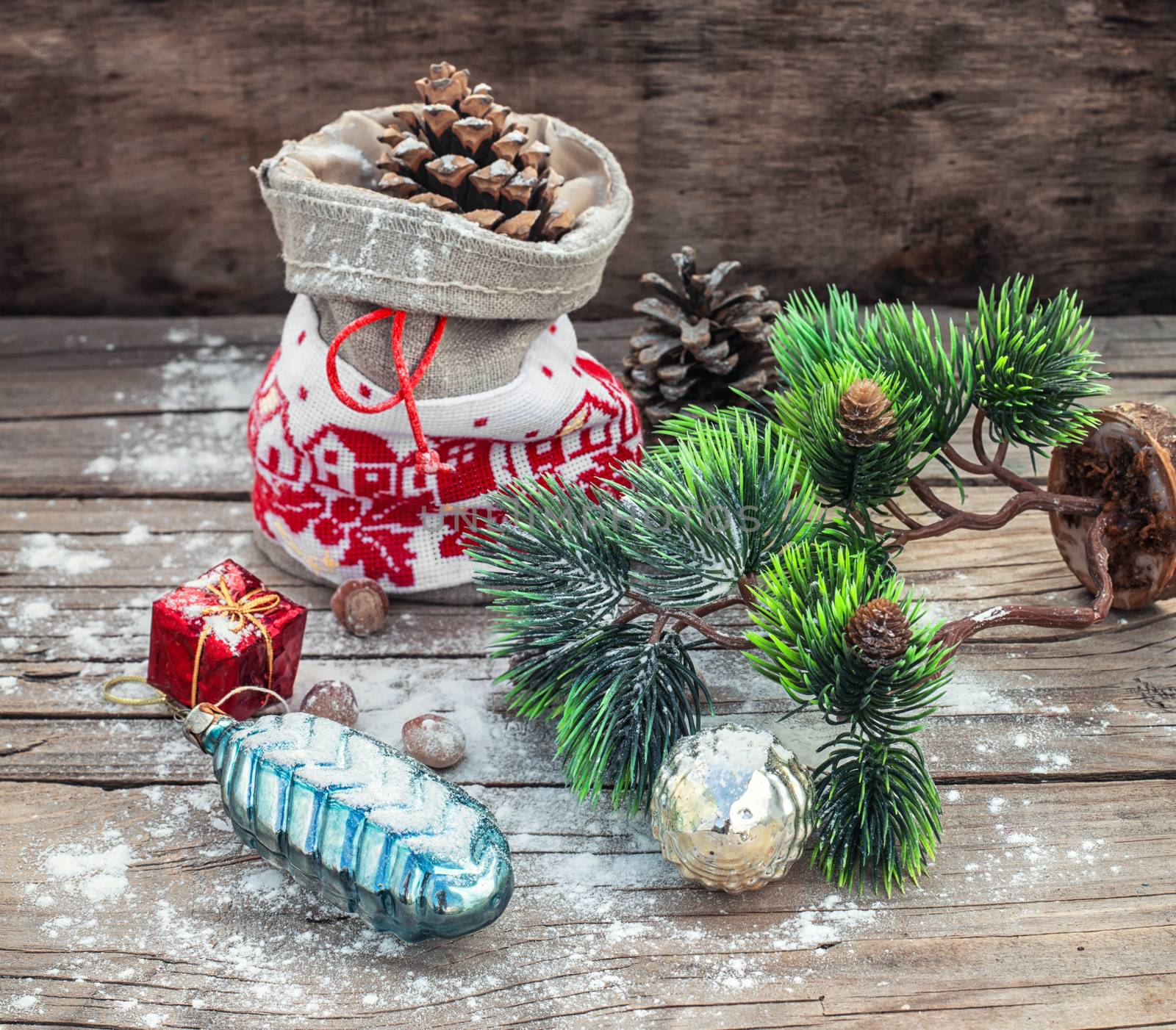 Vintage pouch with cones on the background of Christmas decoration.