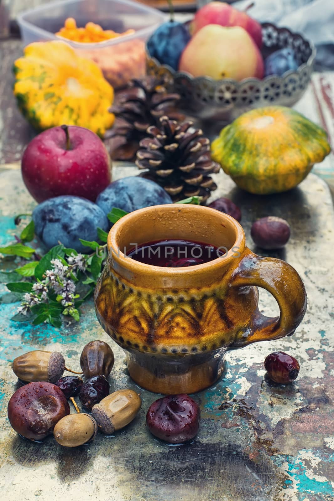 Fashion clay cup on the background of harvest of autumn fruits.