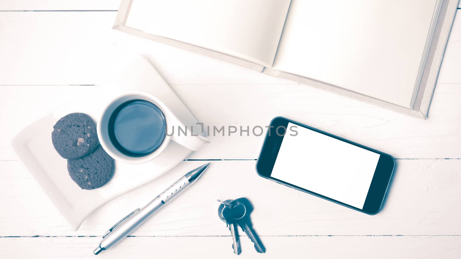 coffee cup with cookie,phone,notebook and key on white wood table vintage style