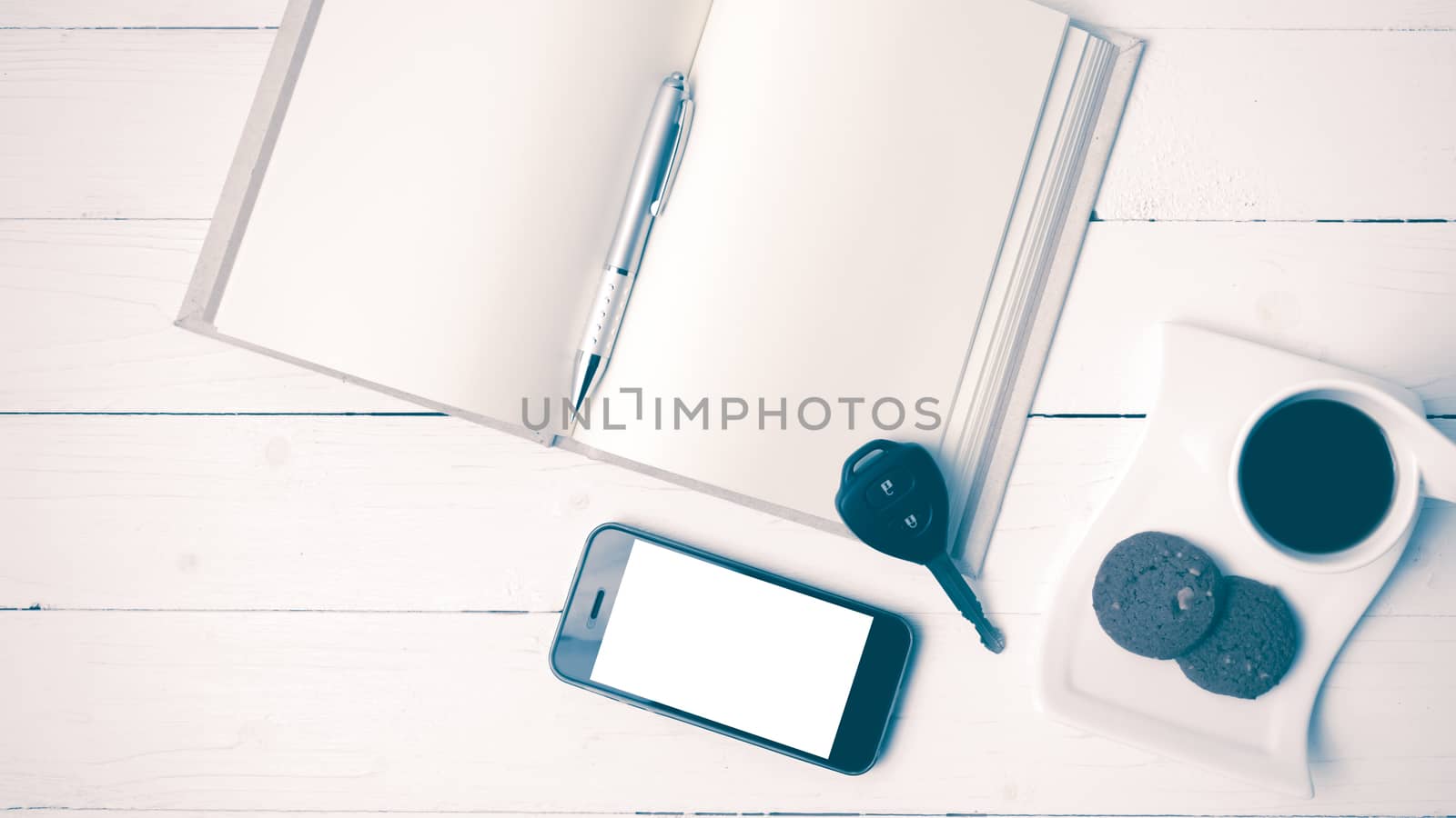 coffee cup with cookie,phone,open notebook and car key on white wood table vintage style
