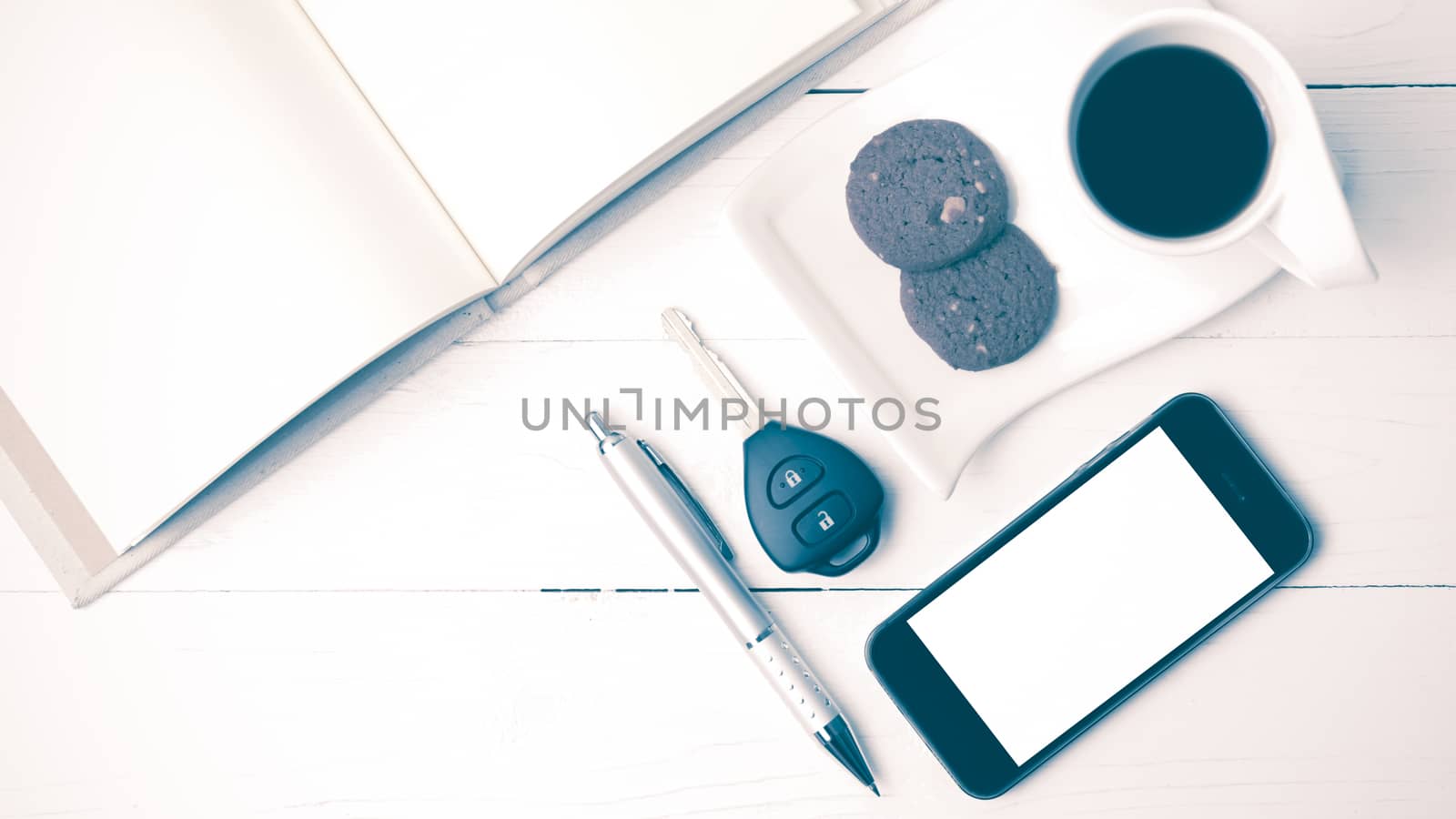 coffee cup with cookie,phone,open notebook and car key on white wood table vintage style