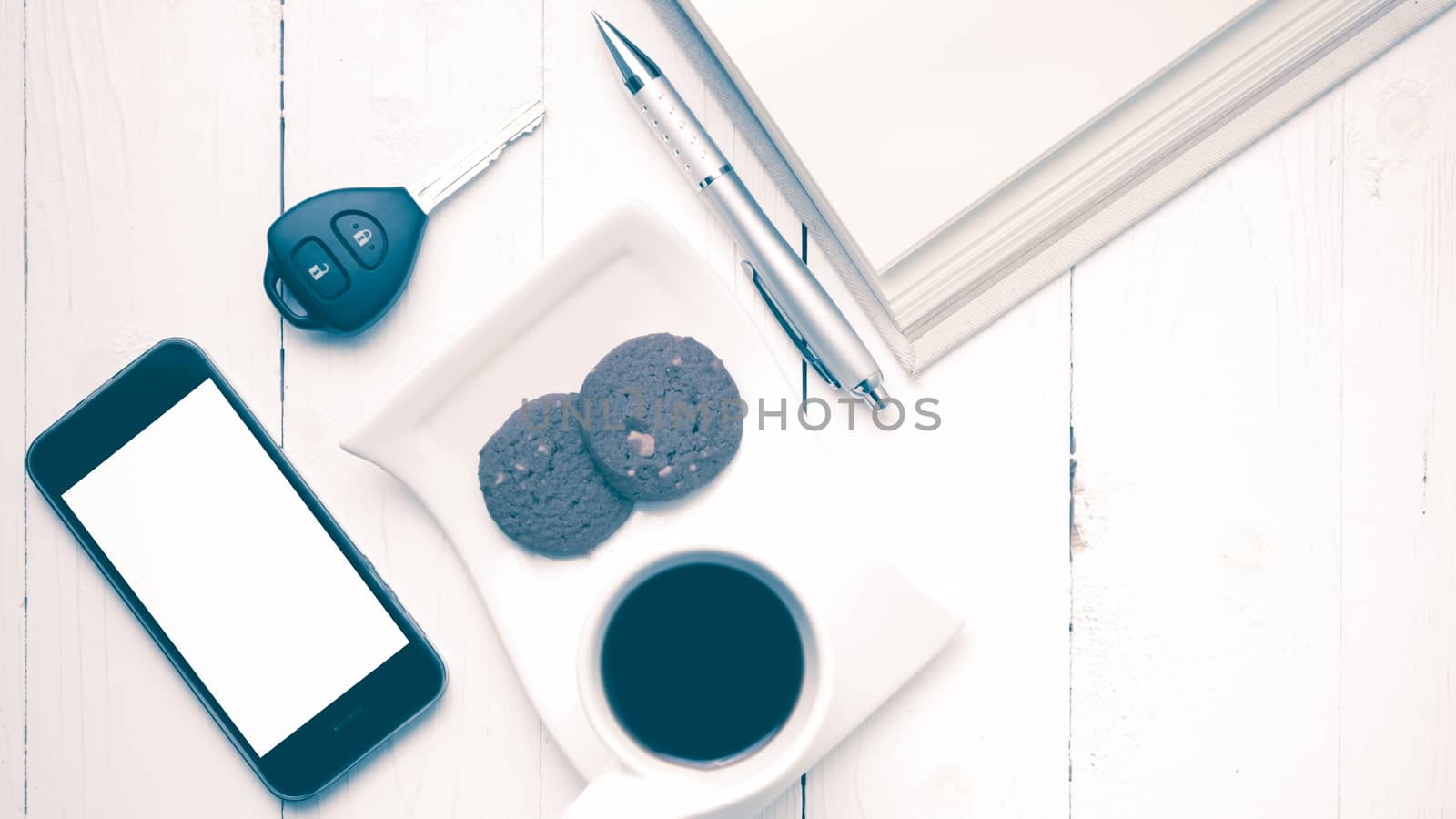 coffee cup with cookie,phone,open notebook and car key on white wood table vintage style