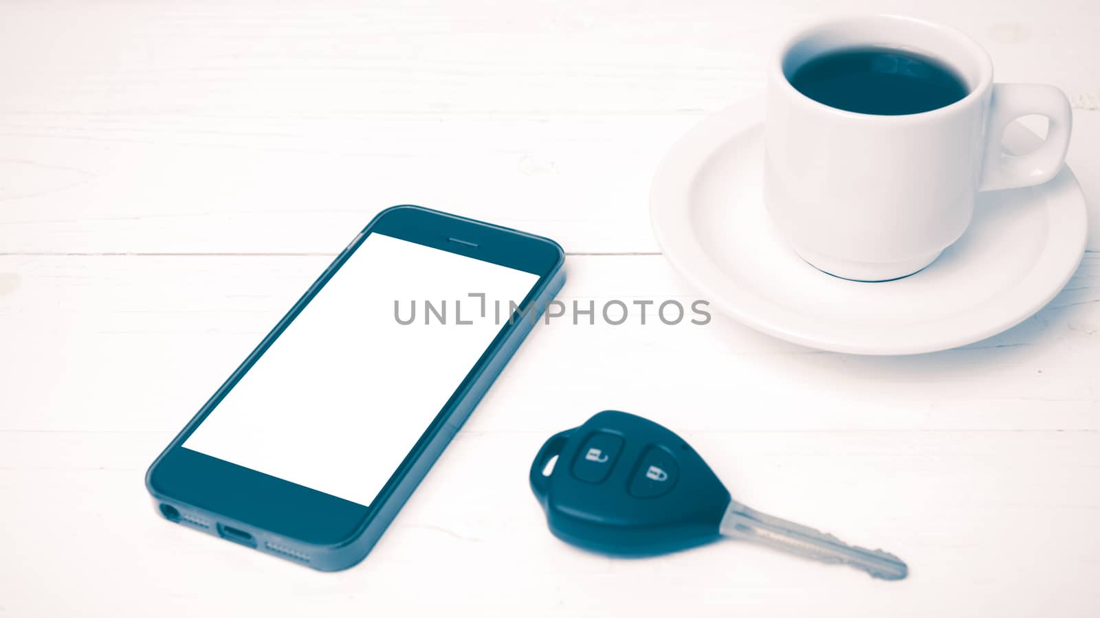 coffee cup with phone and car key on white wood table vintage style