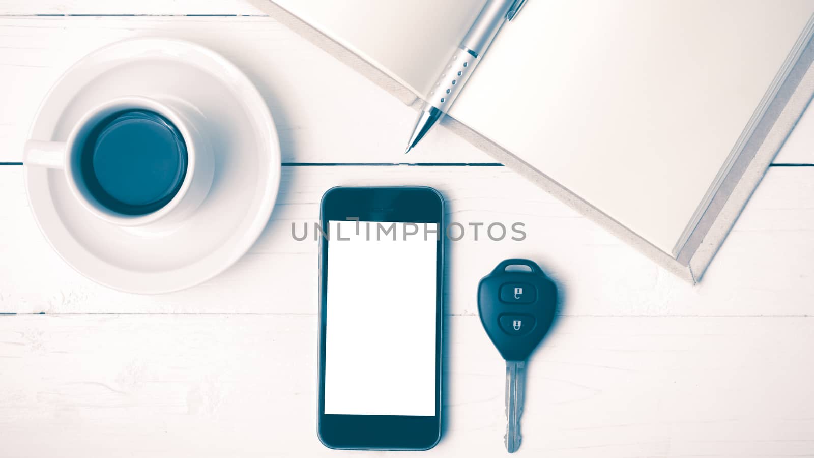 coffee cup with phone,car key and open notebook on white wood table vintage style