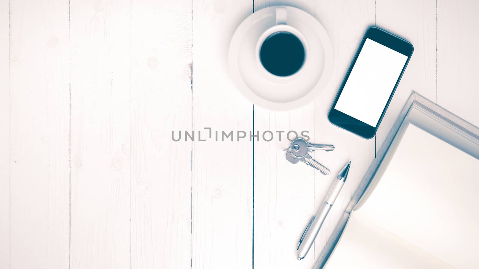 coffee cup with phone, key and open notebook on white wood table vintage style